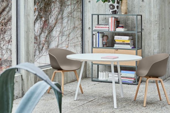 Zwei About A Chair AAC22 Stühle mit Eichegestell und einem weißen Tisch.