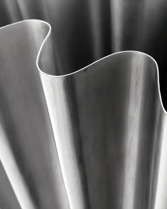 Detailaufnahme der Vase HDFlood von House Doctor mit gebürstetem Silber-Finish und wellenförmigem Design.
