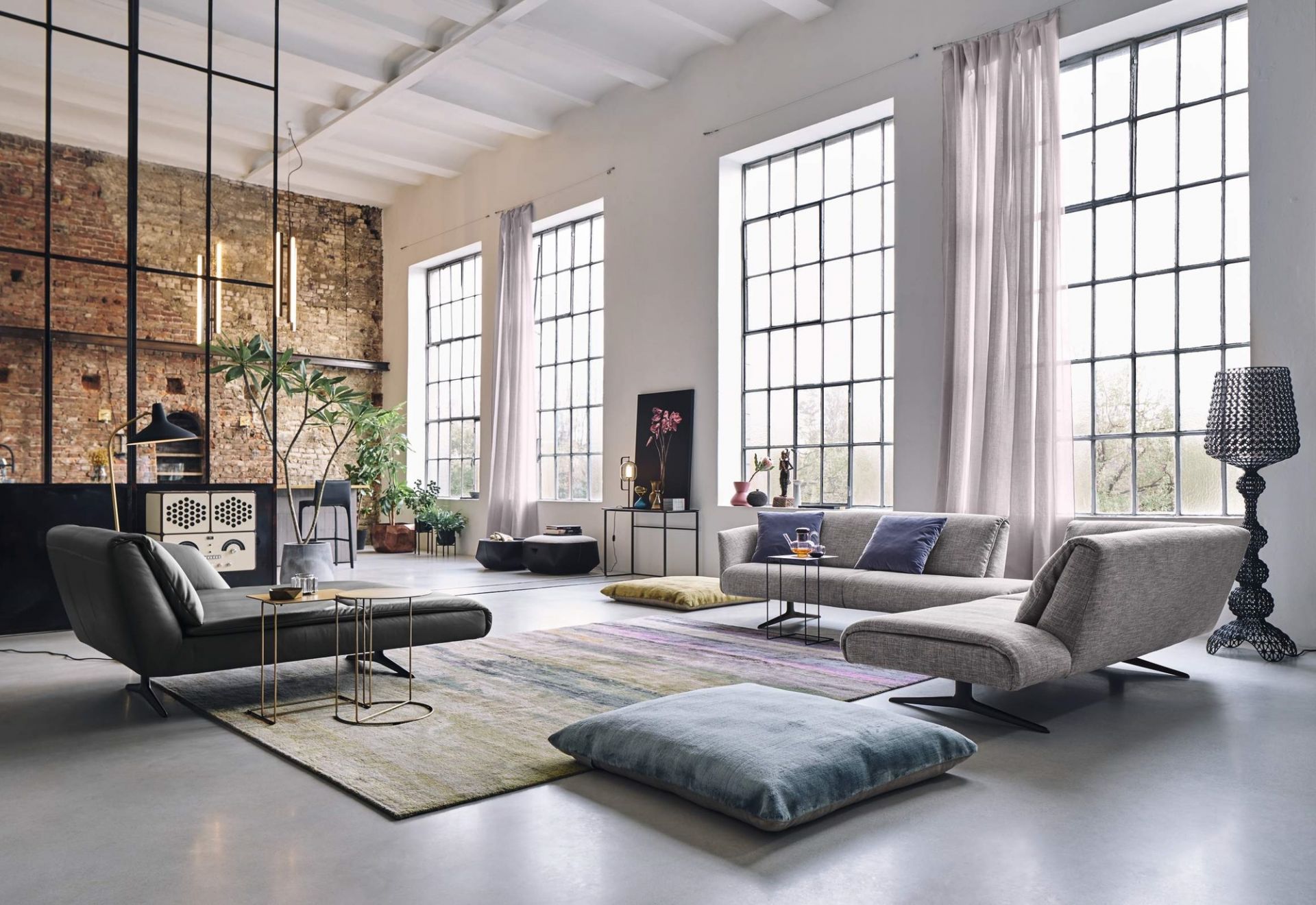 Helles Wohnzimmer mit Walter Knoll Möbeln: Sofa, Sessel, Teppich und Oki Beistelltisch mit goldfarbenem Gestell.