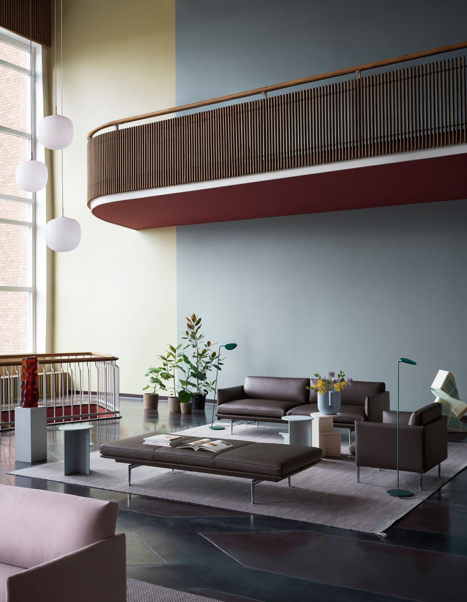 Helle Rime Pendelleuchten von Muuto über einem modern eingerichteten Wohnzimmer mit grauen Möbeln.