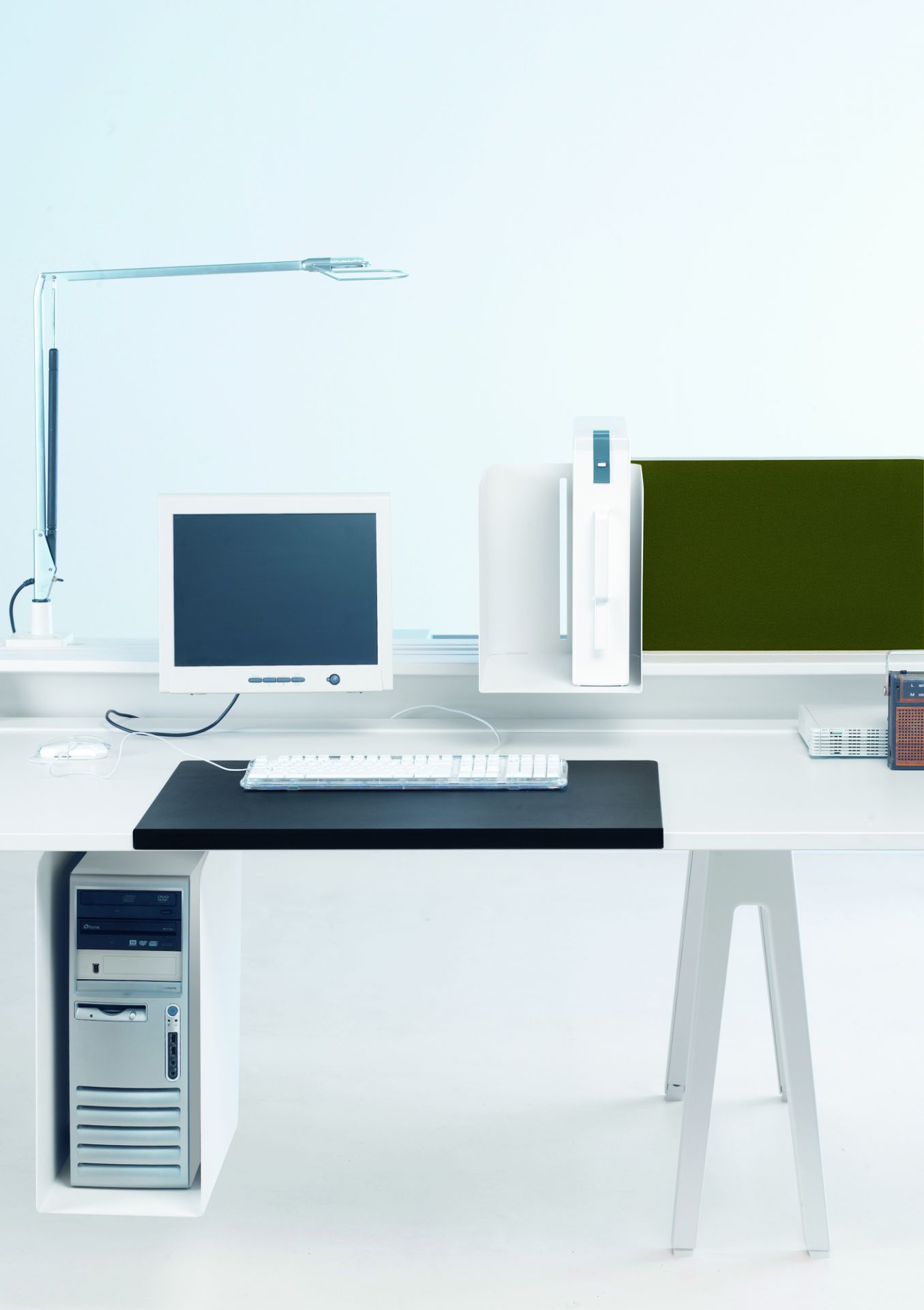 Schwarze Joyn Schreibtischunterlage von Vitra auf einem weißen Schreibtisch mit Computer, Tastatur und Schreibtischlampe.