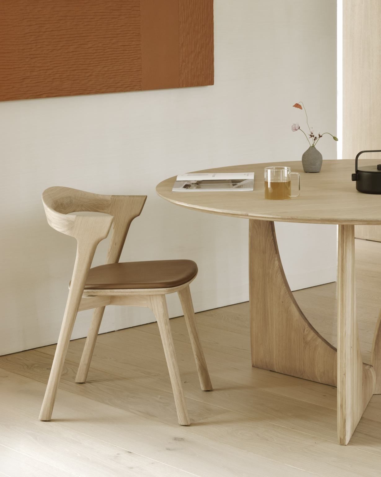 Ethnicraft Geometric Dining Table aus Eiche mit passendem Stuhl und Dekoration auf Holzboden.