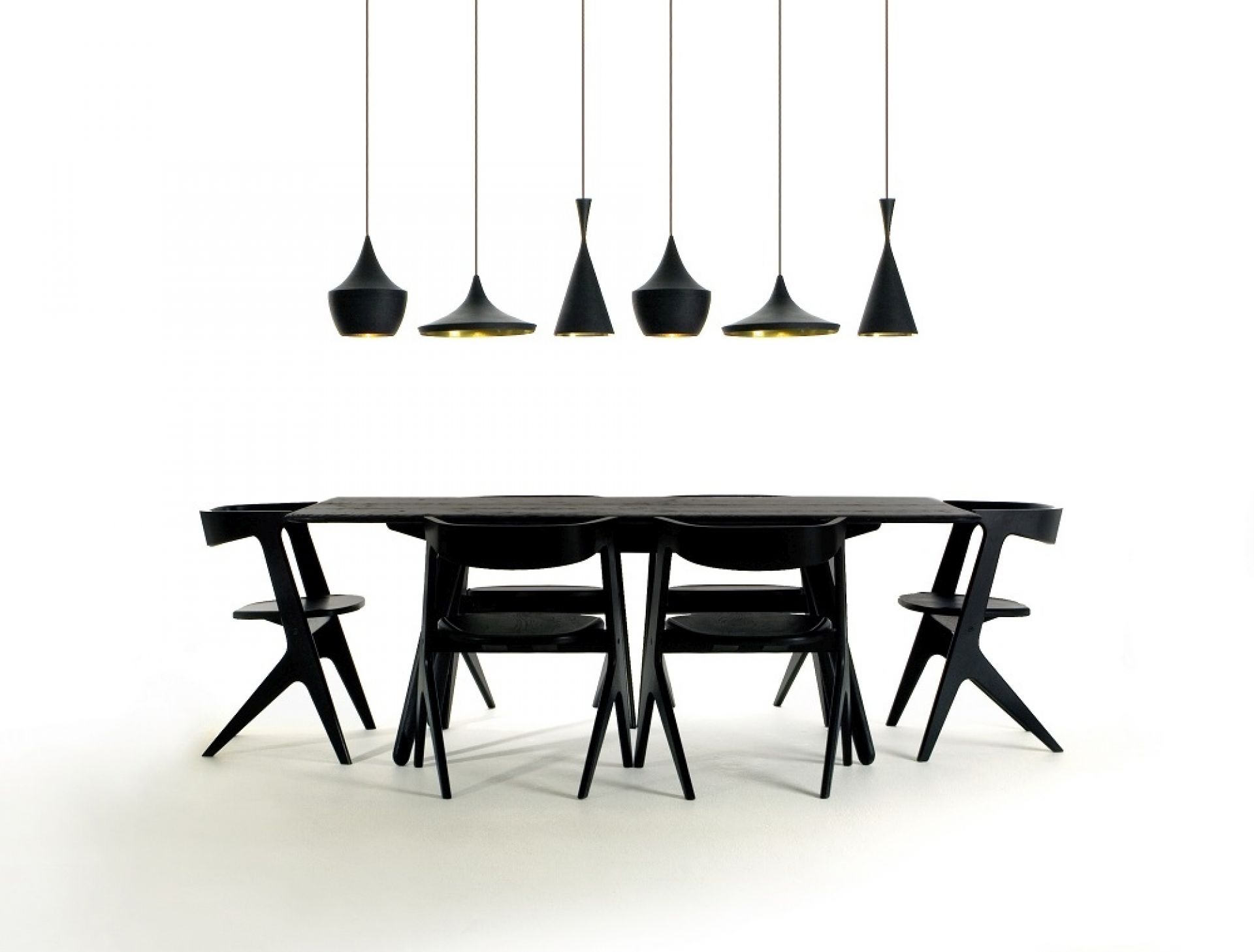 Weiße Beat Fat LED Pendelleuchte von Tom Dixon über schwarzem Esstisch mit Stühlen. Design Lampe.