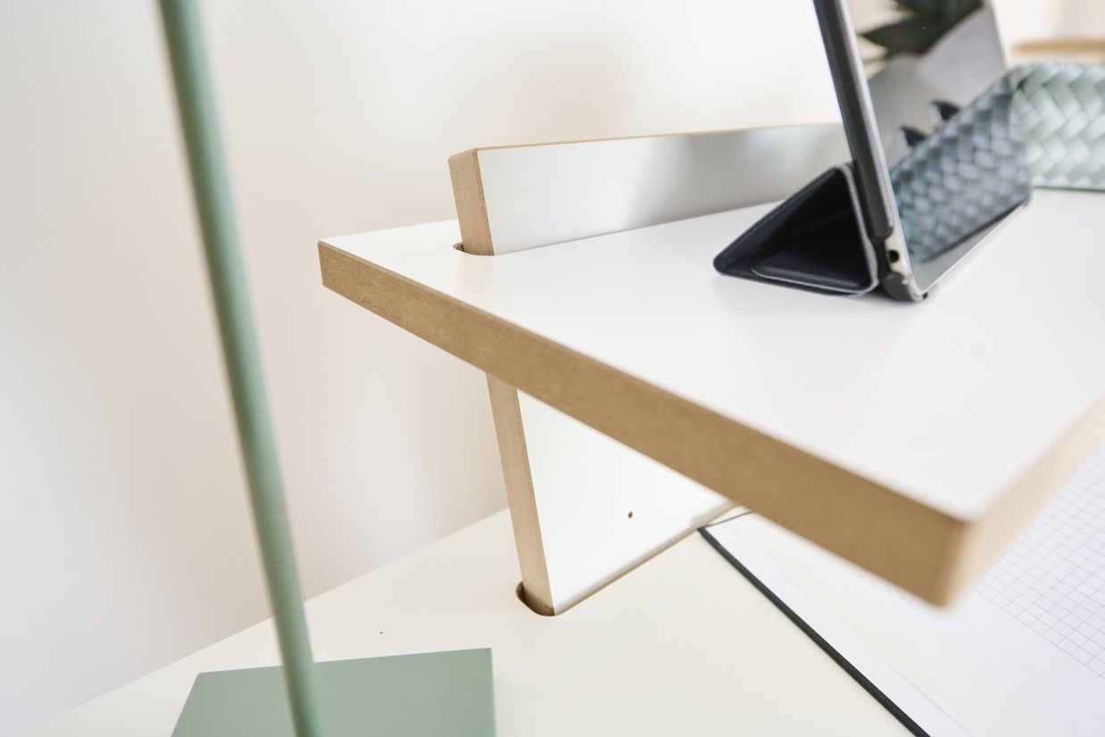 Detailaufnahme des Tojo Pult Stehpults mit Laptop, Notizblock und minimalistischer Schreibtischlampe.