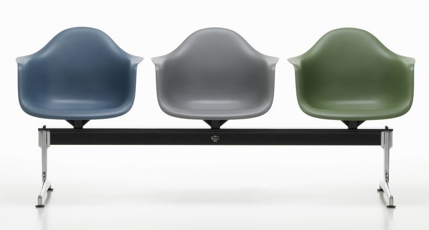 Eames Plastic Armchair RE auf Traverse Vitra, Wartebereich mit drei farbigen Kunststoffschalen auf schwarzem Gestell.