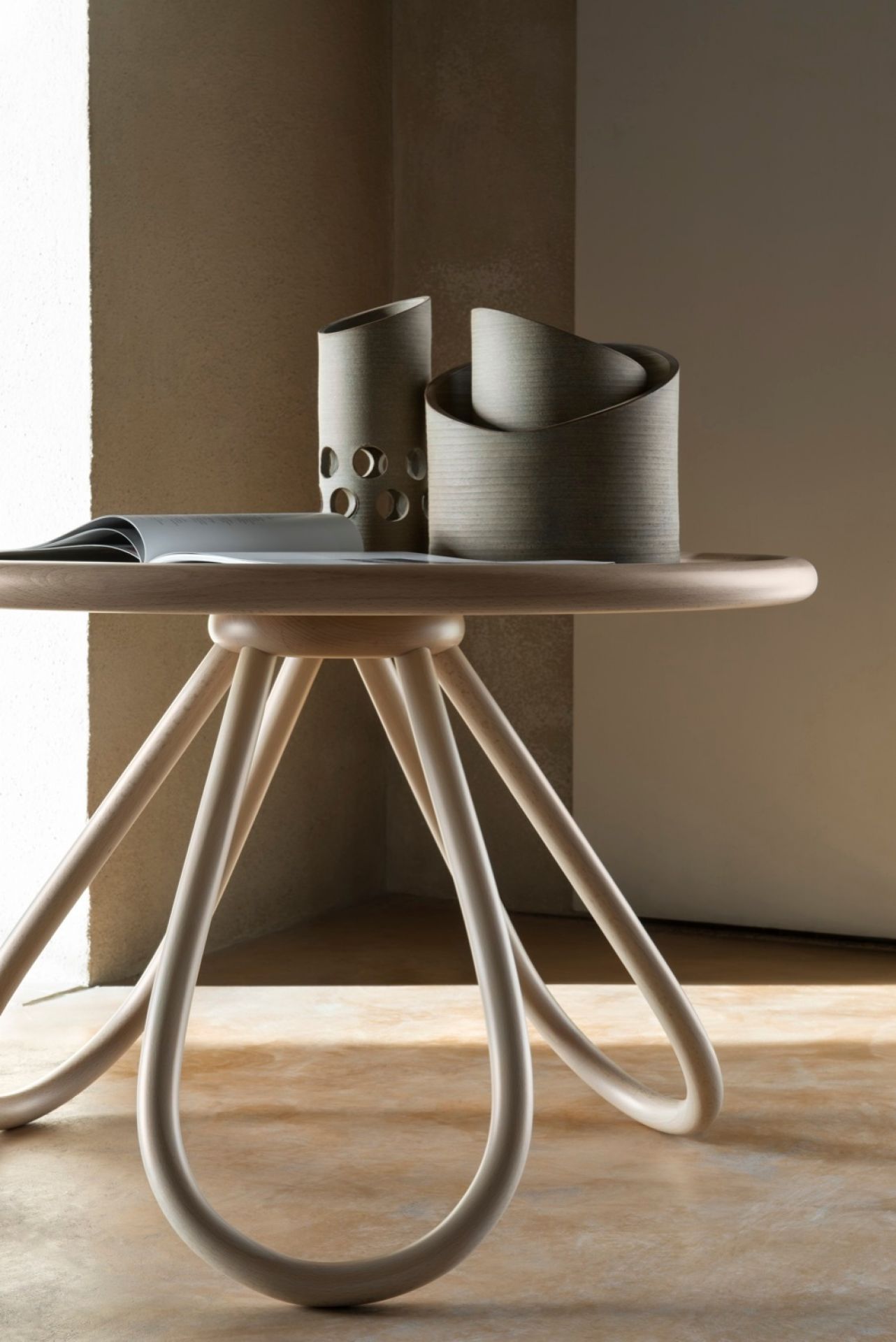 Arch Couchtisch von Wiener GTV Design: Runder Holztisch mit gebogenen Beinen und Dekoration.