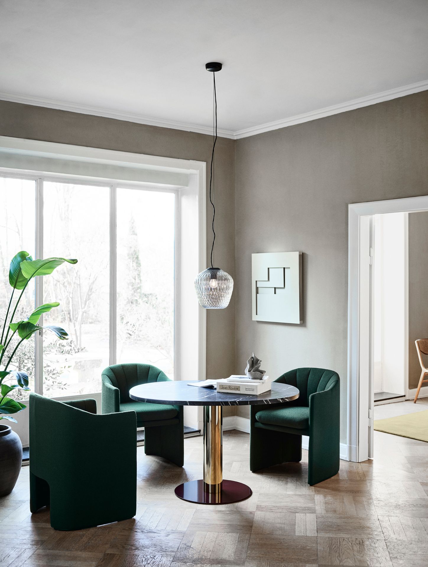 AndTradition Blown SW3 Pendelleuchte über Esstisch mit grünen Stühlen, modernes Design.