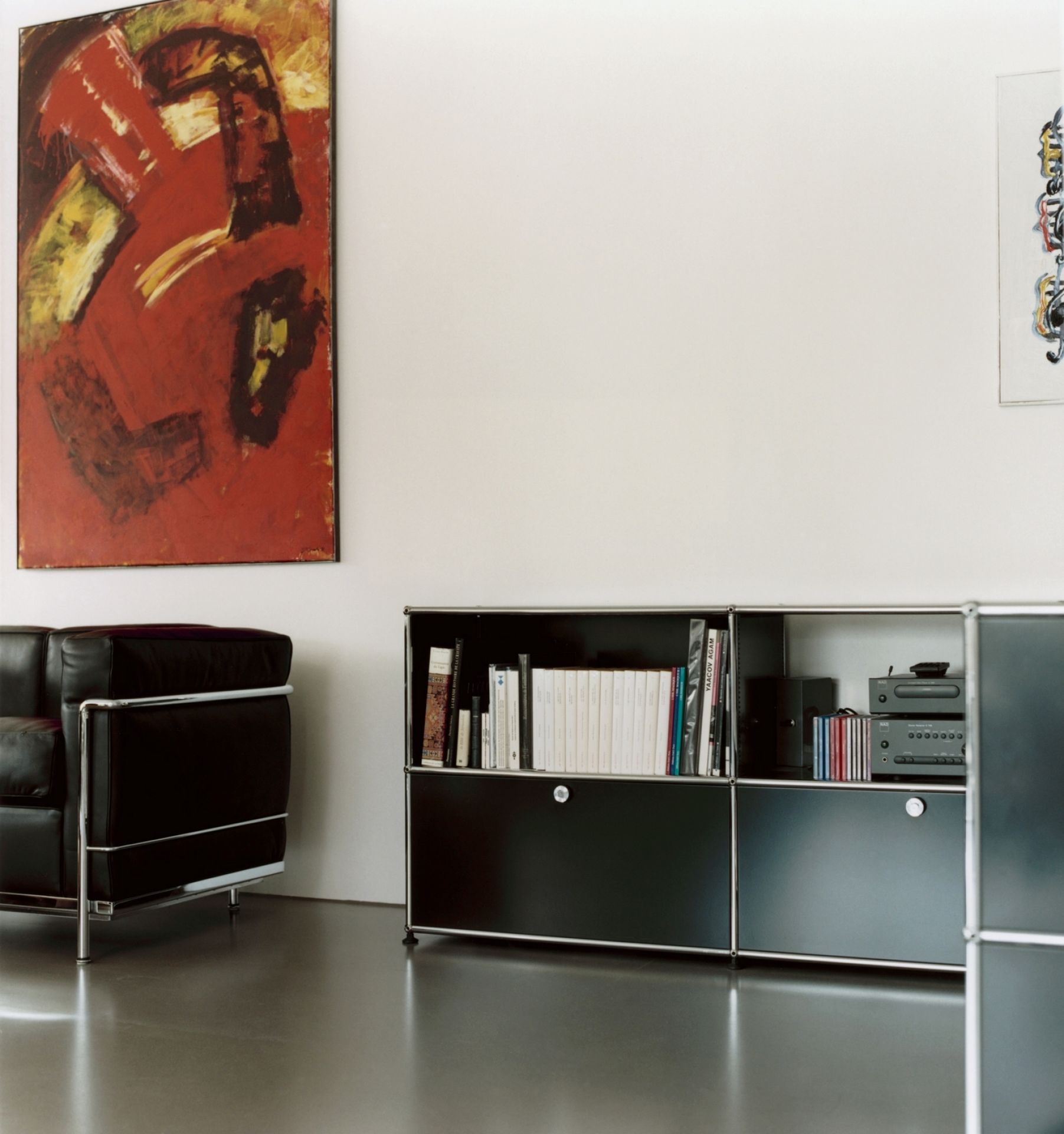 Nahaufnahme eines schwarzen USM Haller Sideboards mit zwei Klappen in einem modernen Wohnzimmer.