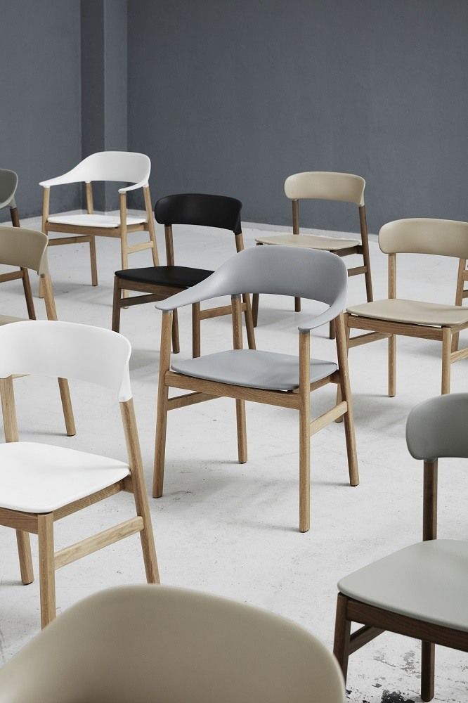 Nahaufnahme von mehreren Herit Chair Stühlen von Normann Copenhagen in verschiedenen Farben und Holzrahmen.