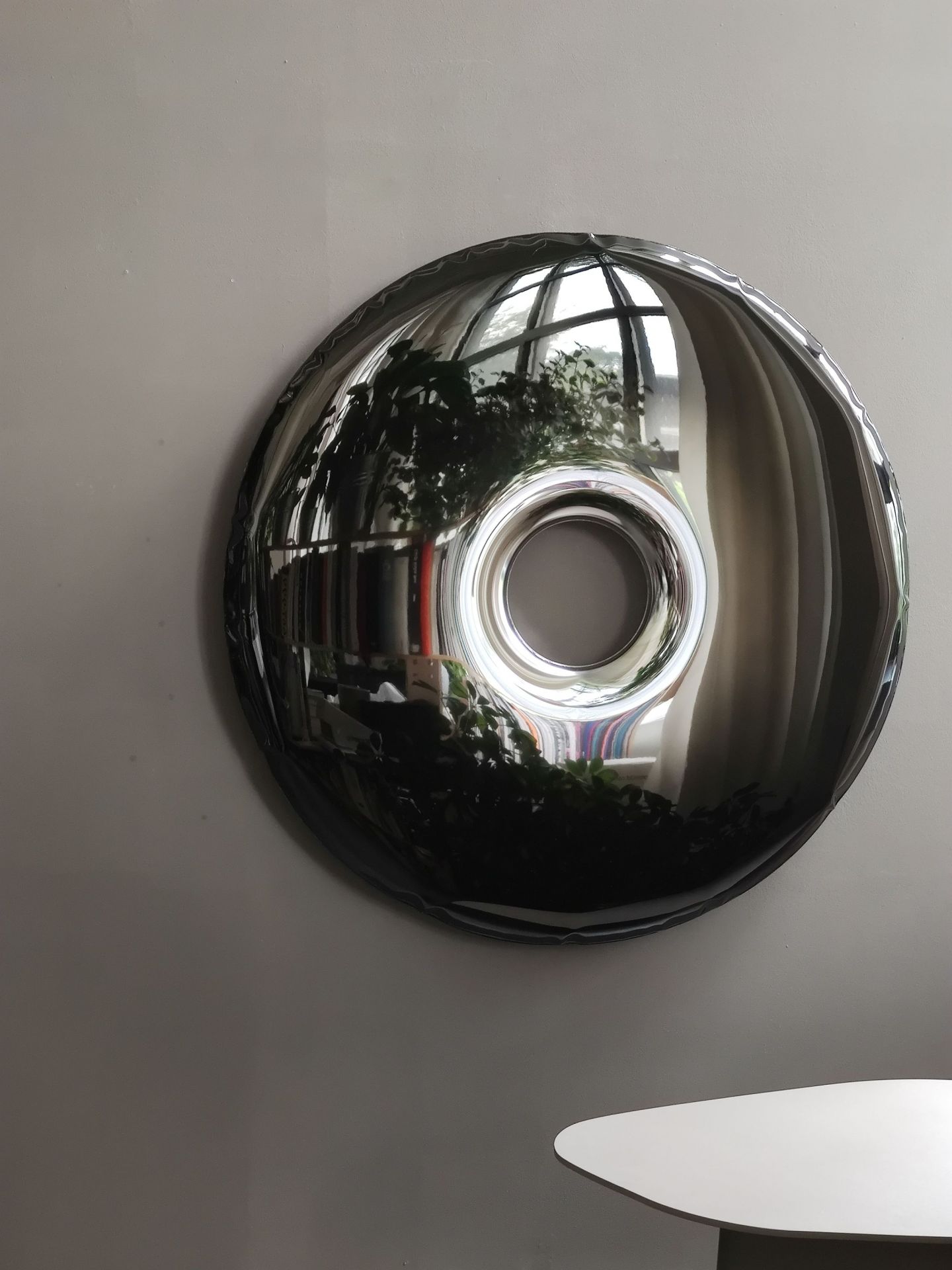 Rondo Wandobjekt von Zieta Studio in dunklem Metall, reflektiert Raum und Licht.