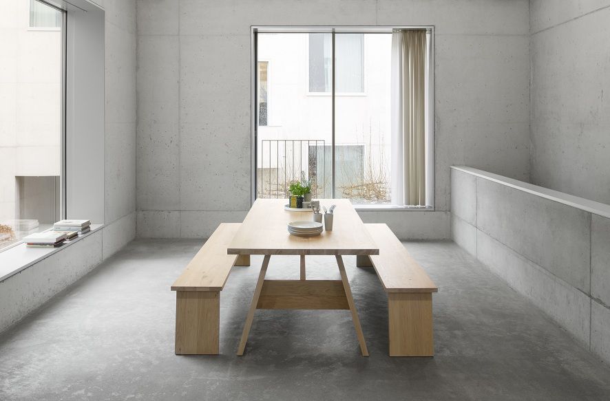 DC01 Fayland Tisch von e15, Esstisch aus geölter Eiche mit zwei passenden Bänken im minimalistischen Raum.