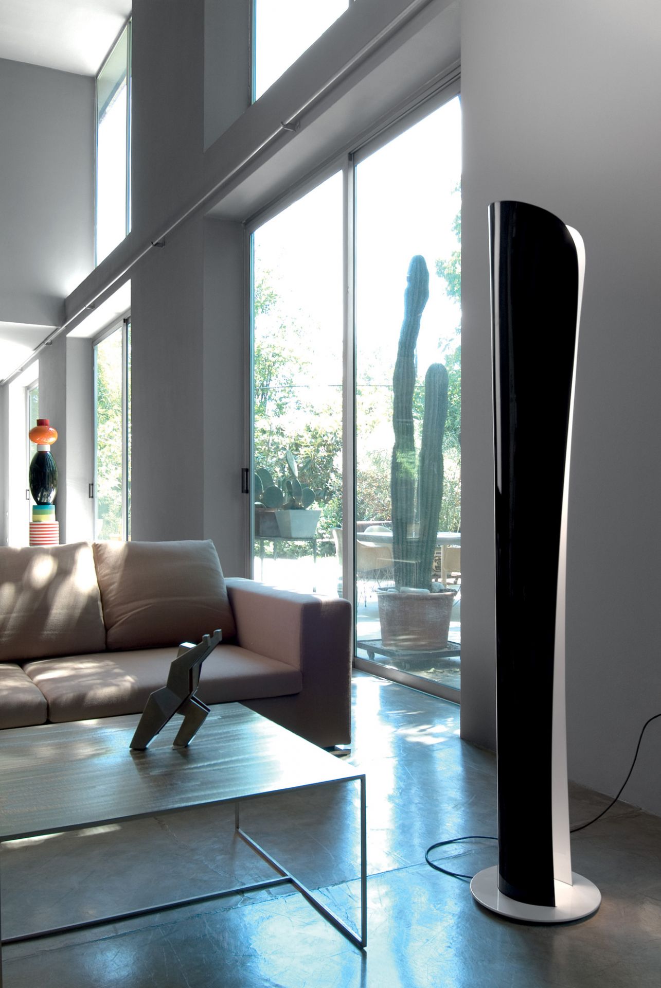 Cadmo LED Stehleuchte von Artemide in Schwarz und Weiß im modernen Wohnzimmer.
