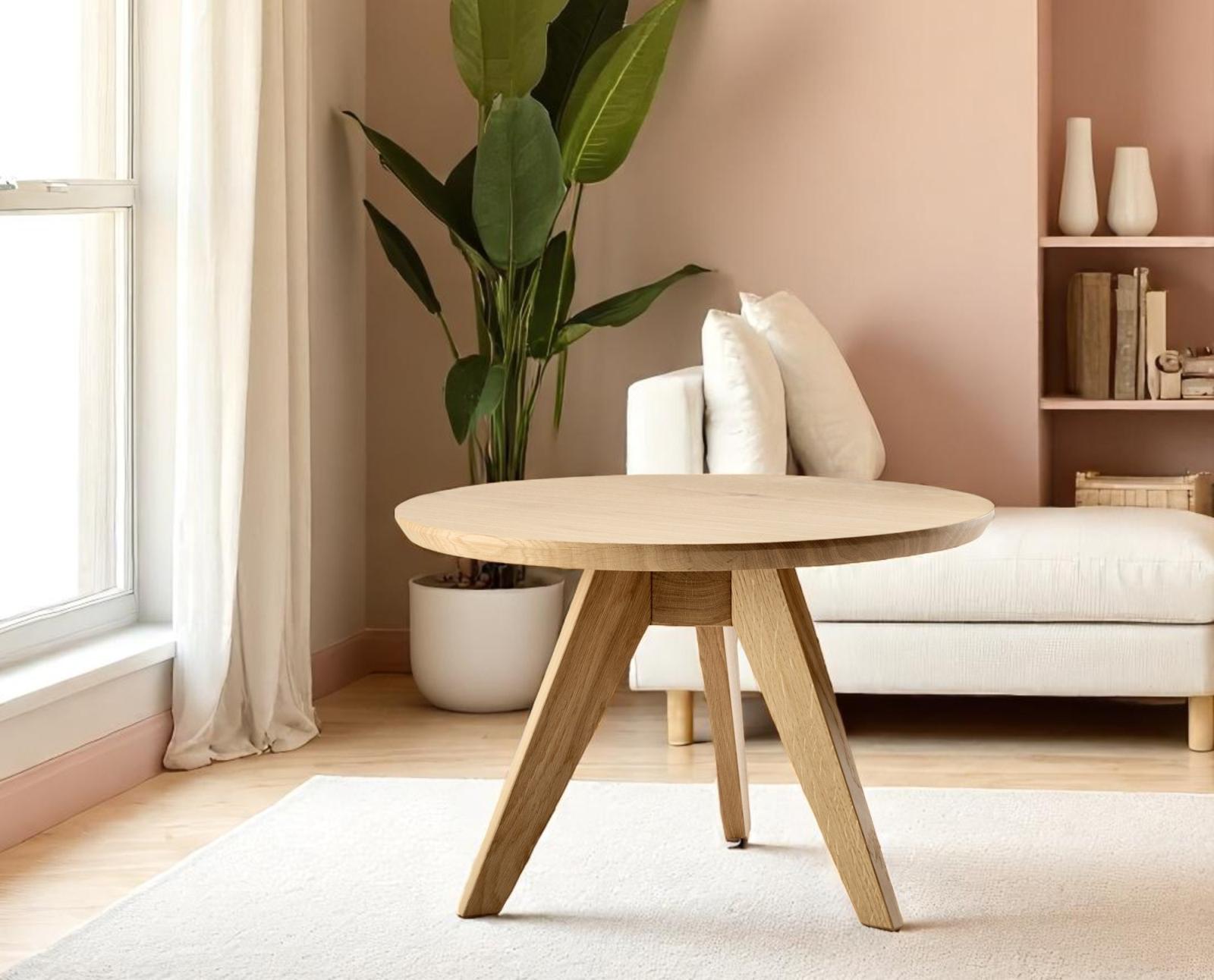 Cena Couchtisch Zeitraum: Runder Couchtisch aus hellem Holz mit drei Beinen im Wohnzimmer.