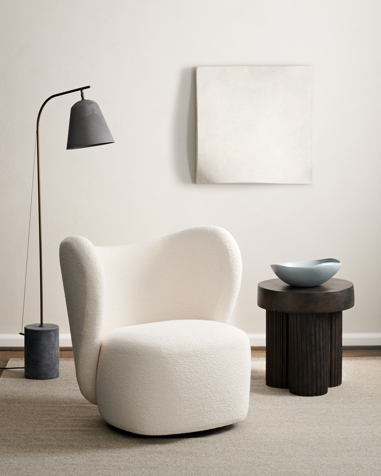 Norr11 Gear Tall Side Table aus dunklem Holz neben Sessel und Stehlampe in minimalistischem Interieur.