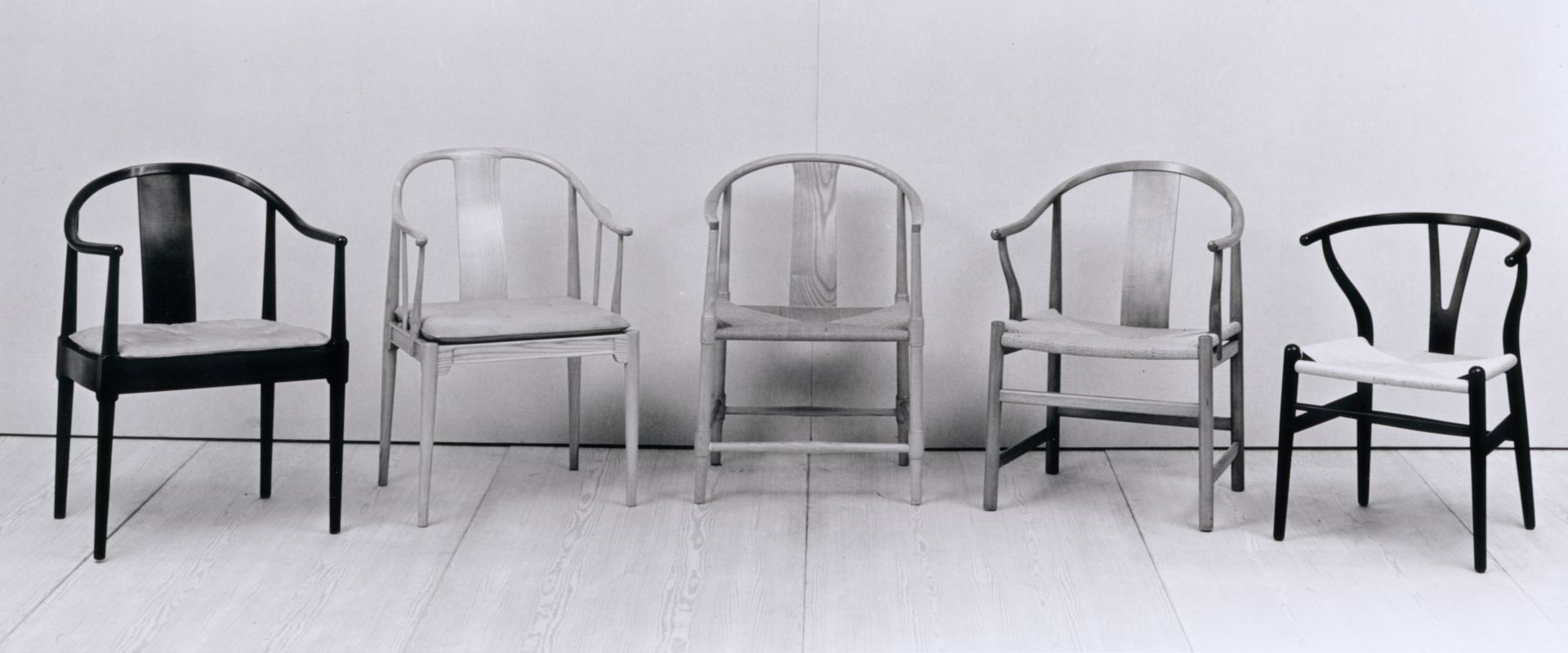 Schwarz-weißes Foto von fünf verschiedenen China Stühlen von Fritz Hansen mit unterschiedlichen Designs und Materialien.