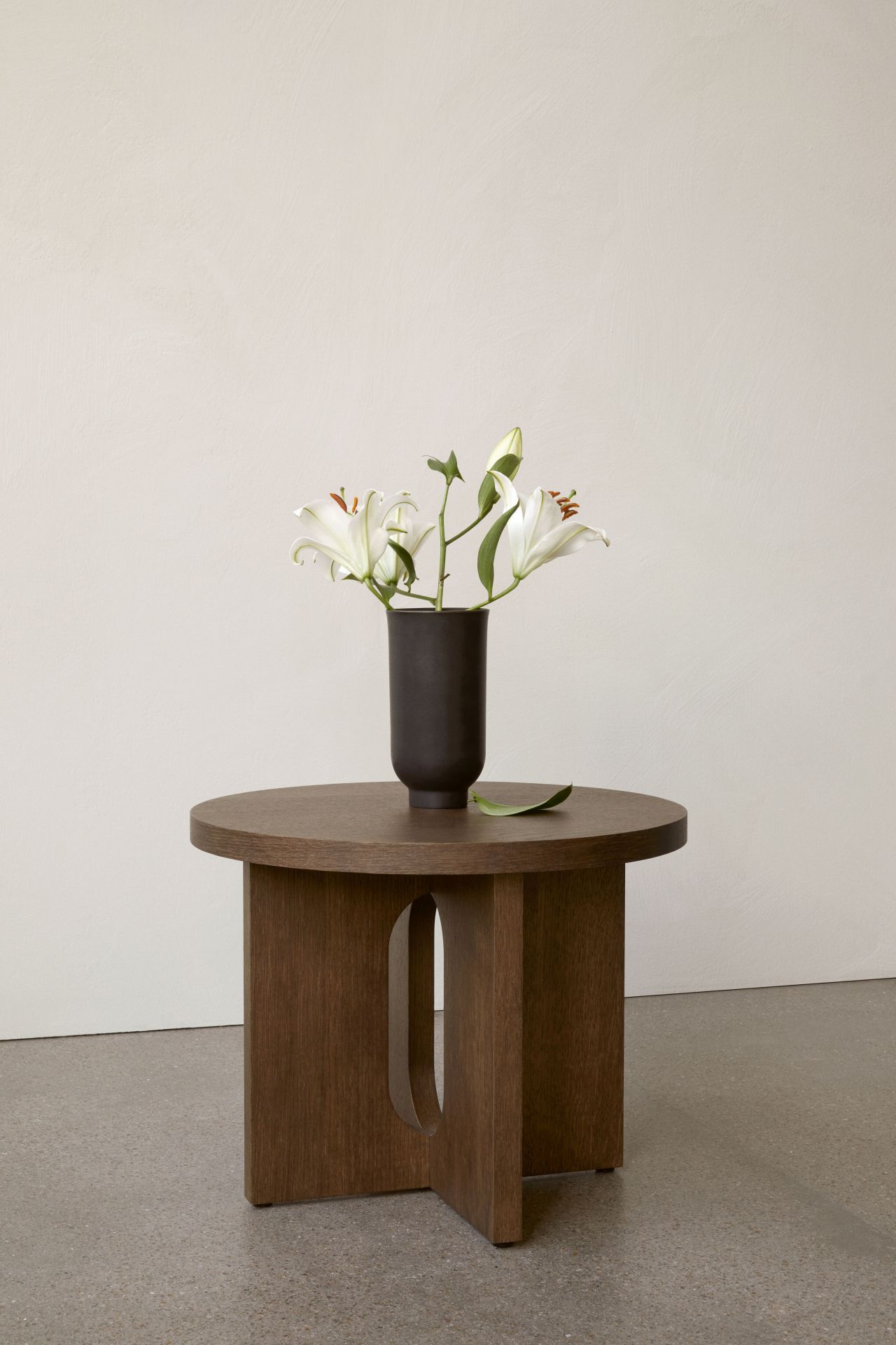 Androgyne Beistelltisch von Audo mit Blumen in dunkler Vase, runder Holztisch für Wohnzimmer.