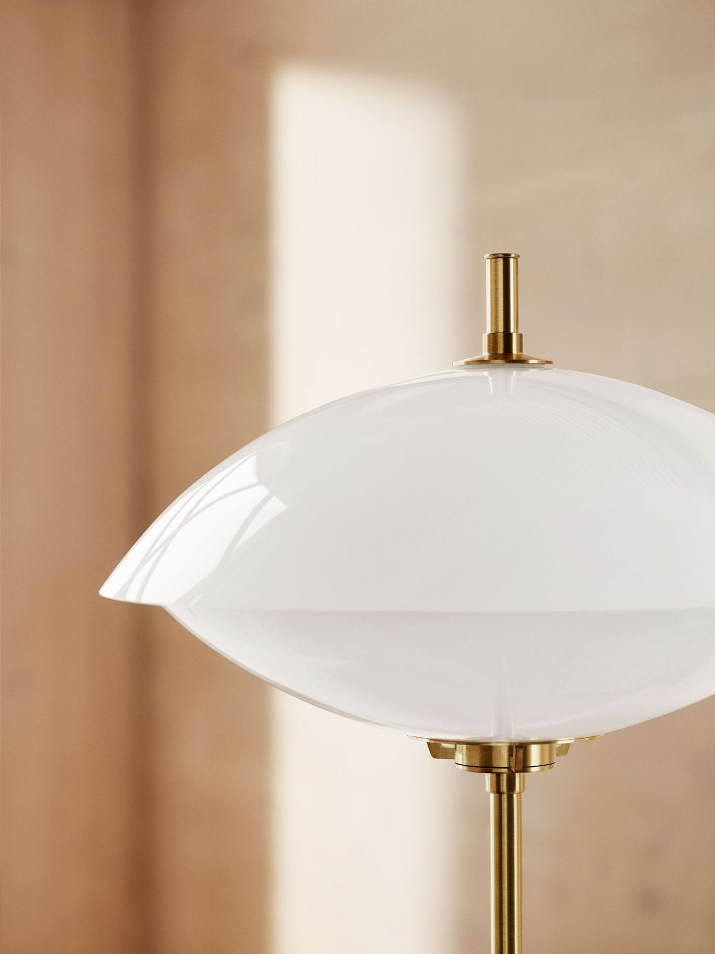 Detailaufnahme der Clam Stehleuchte von Fritz Hansen mit weißem Schirm und Messingfuß.