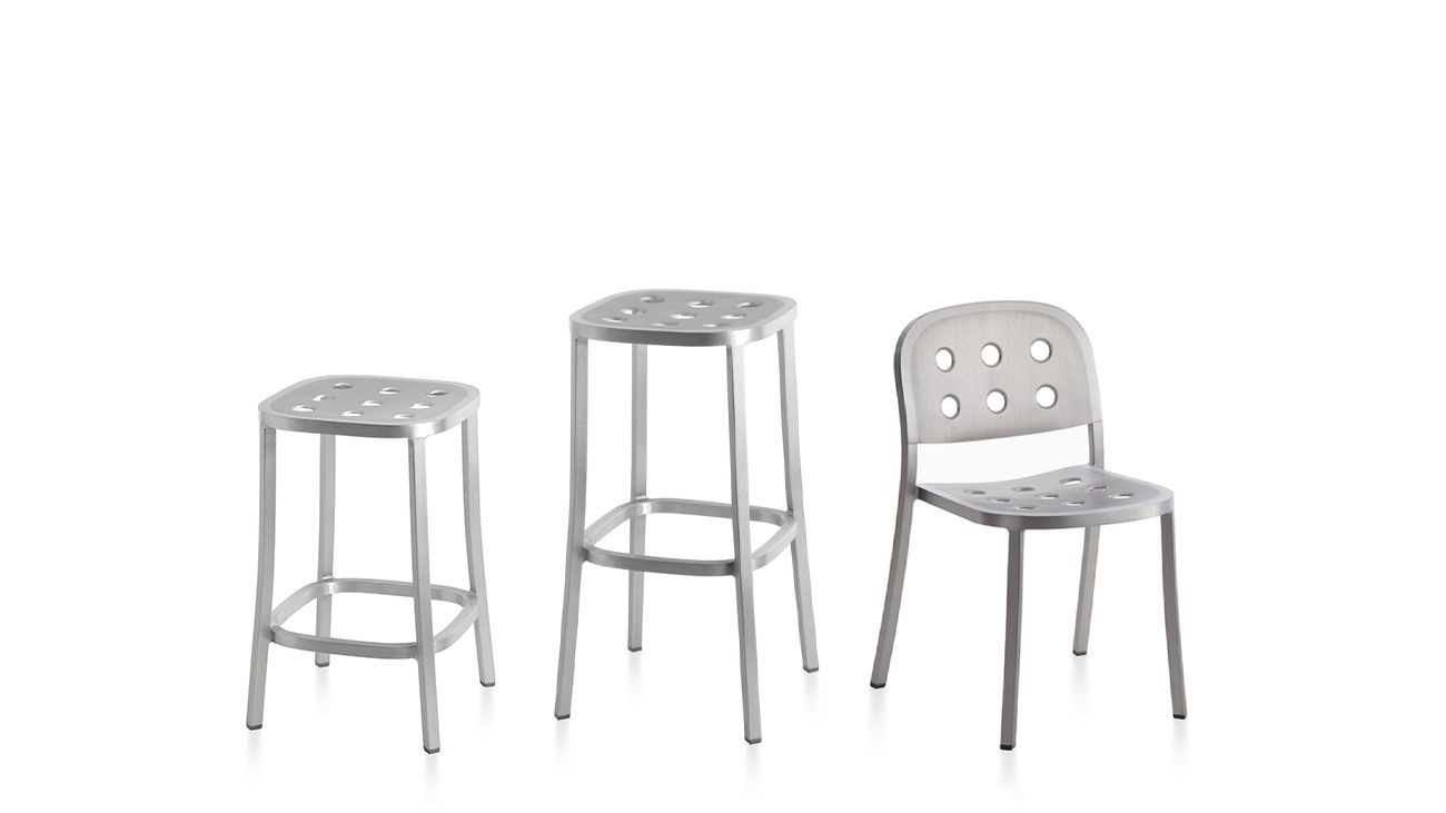 Drei Emeco 1 Inch Aluminium Hocker und Stuhl mit Löchern auf weißem Hintergrund.