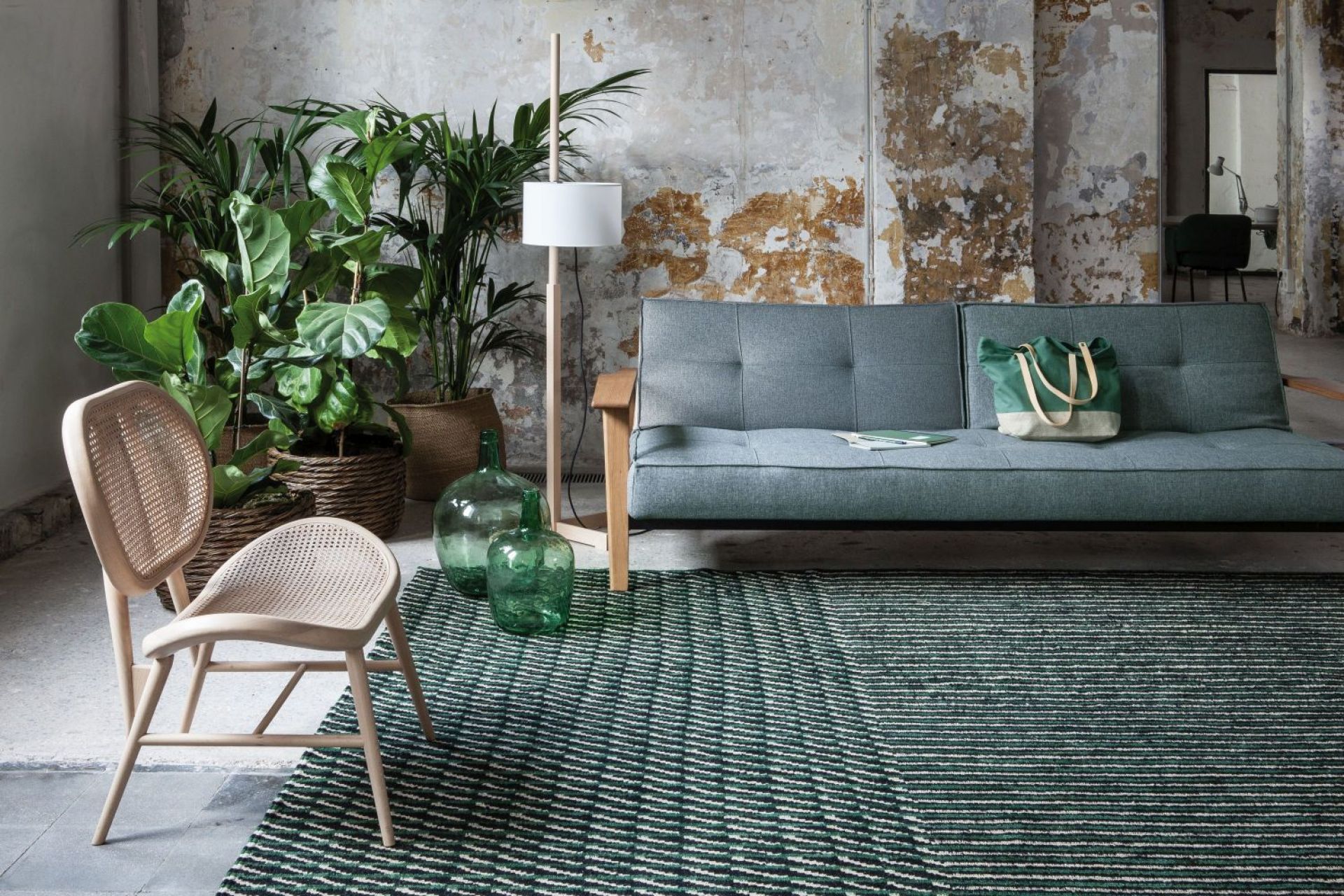 Detailaufnahme des Nanimarquina Blur Teppichs mit grün-weißem Streifenmuster in einem Wohnzimmer.