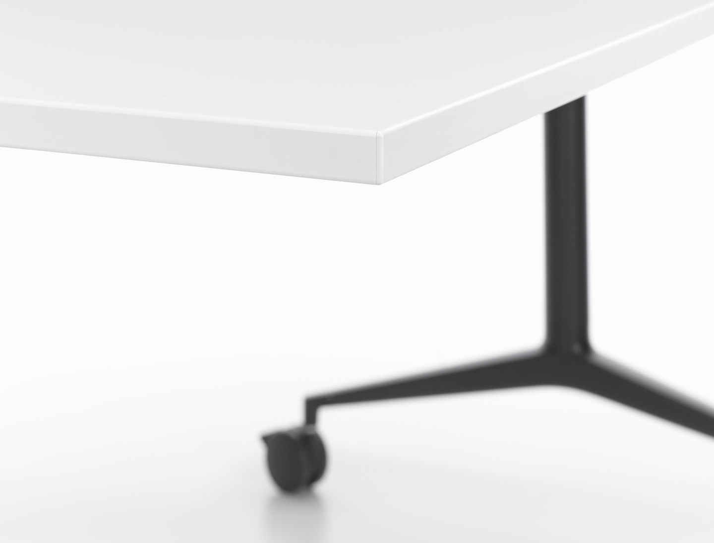 Detailaufnahme vom Vitra MedaMorph Klapptisch: Weiße Tischplatte und schwarzes Gestell mit Rollen.