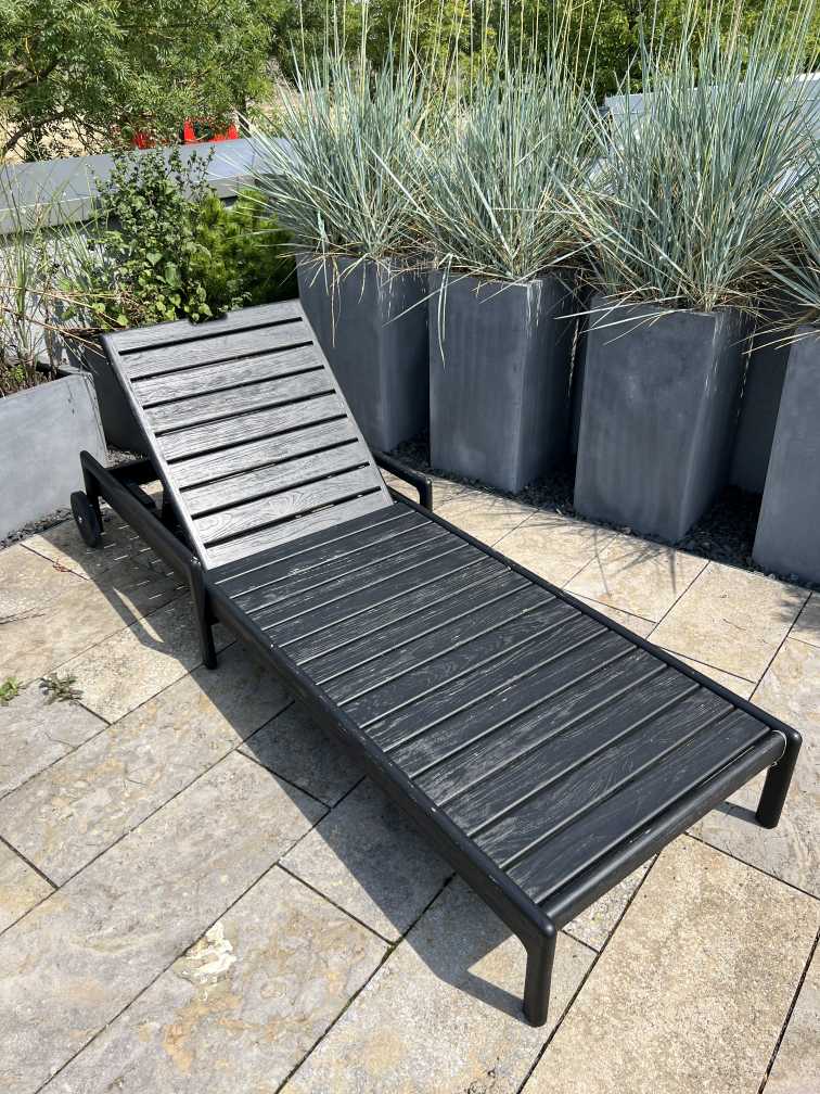 Jack Outdoor Liege aus Teakholz, schwarz lackiert, mit verstellbarer Rückenlehne und Rollen für den Garten.