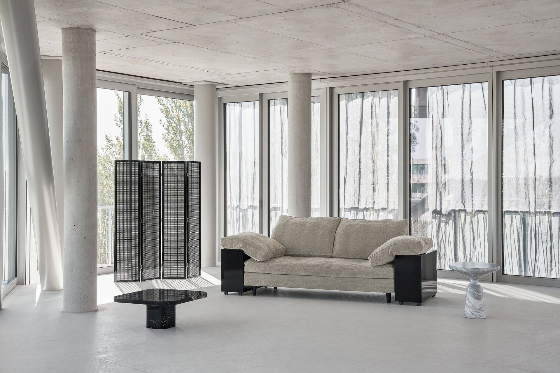 Helles Wohnzimmer mit Classicon Lota Sofa in Beige, schwarzen Akzenten und minimalistischem Design.