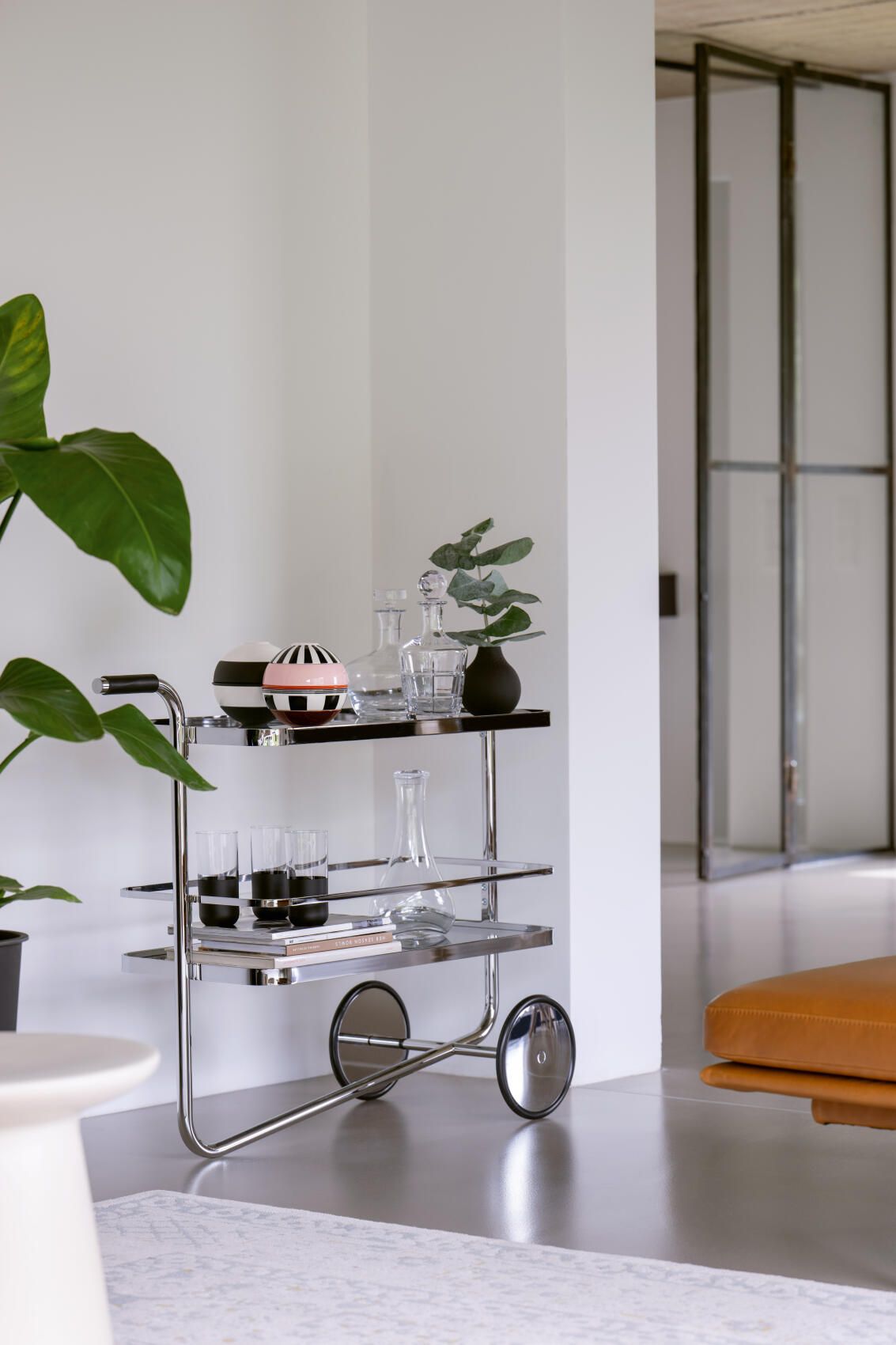 Thonet S 179 Barwagen aus Stahlrohr mit Glasböden, dekoriert mit Gläsern und Karaffen.