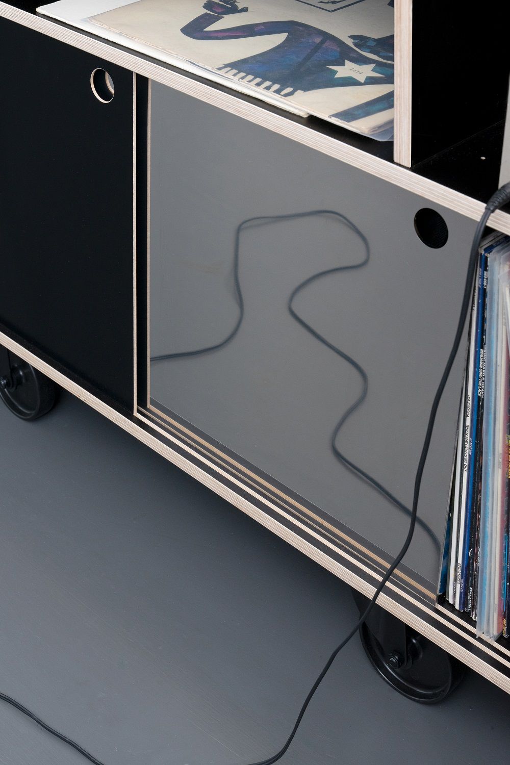 Detailaufnahme vom Egal Rockboard Sideboard von Nils Holger Moormann mit Schallplatten und schwarzem Stromkabel.