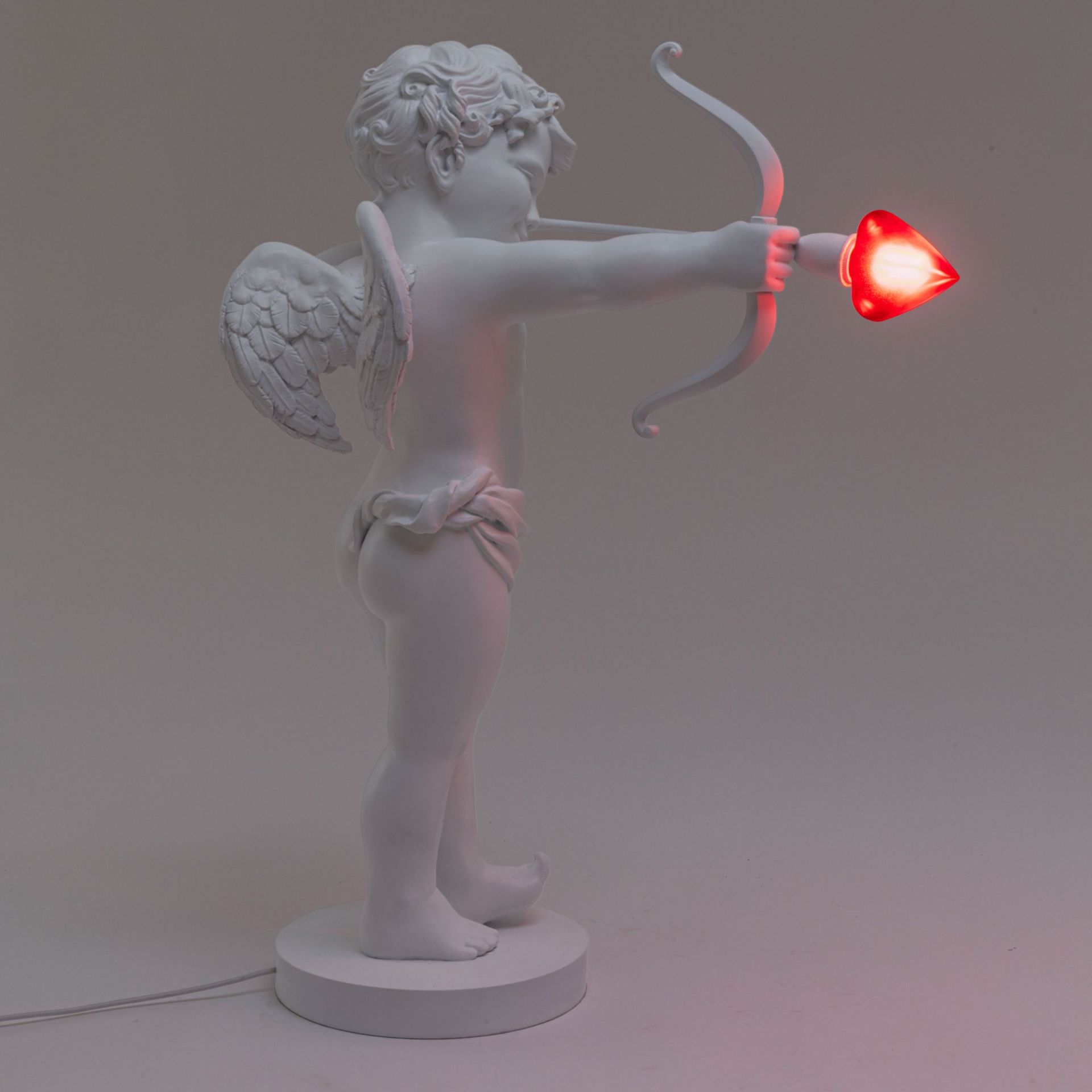 Weiße Cupid Lampe von Seletti: Amor Figur mit Pfeil und Herz als Tischleuchte.