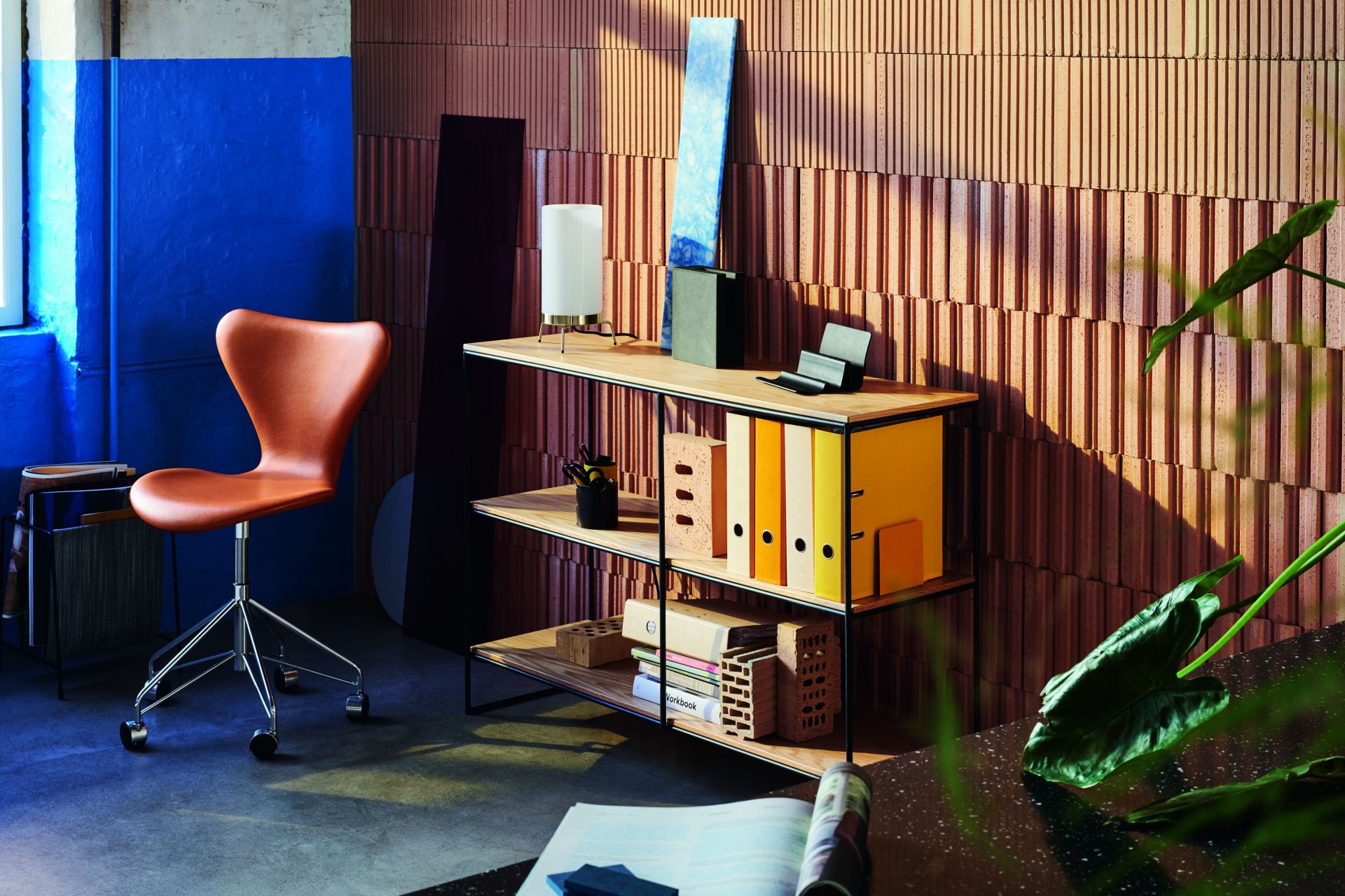 Brauner Siebener Drehstuhl von Fritz Hansen, ein Designklassiker für Büro und Wohnraum, vor modernem Hintergrund.