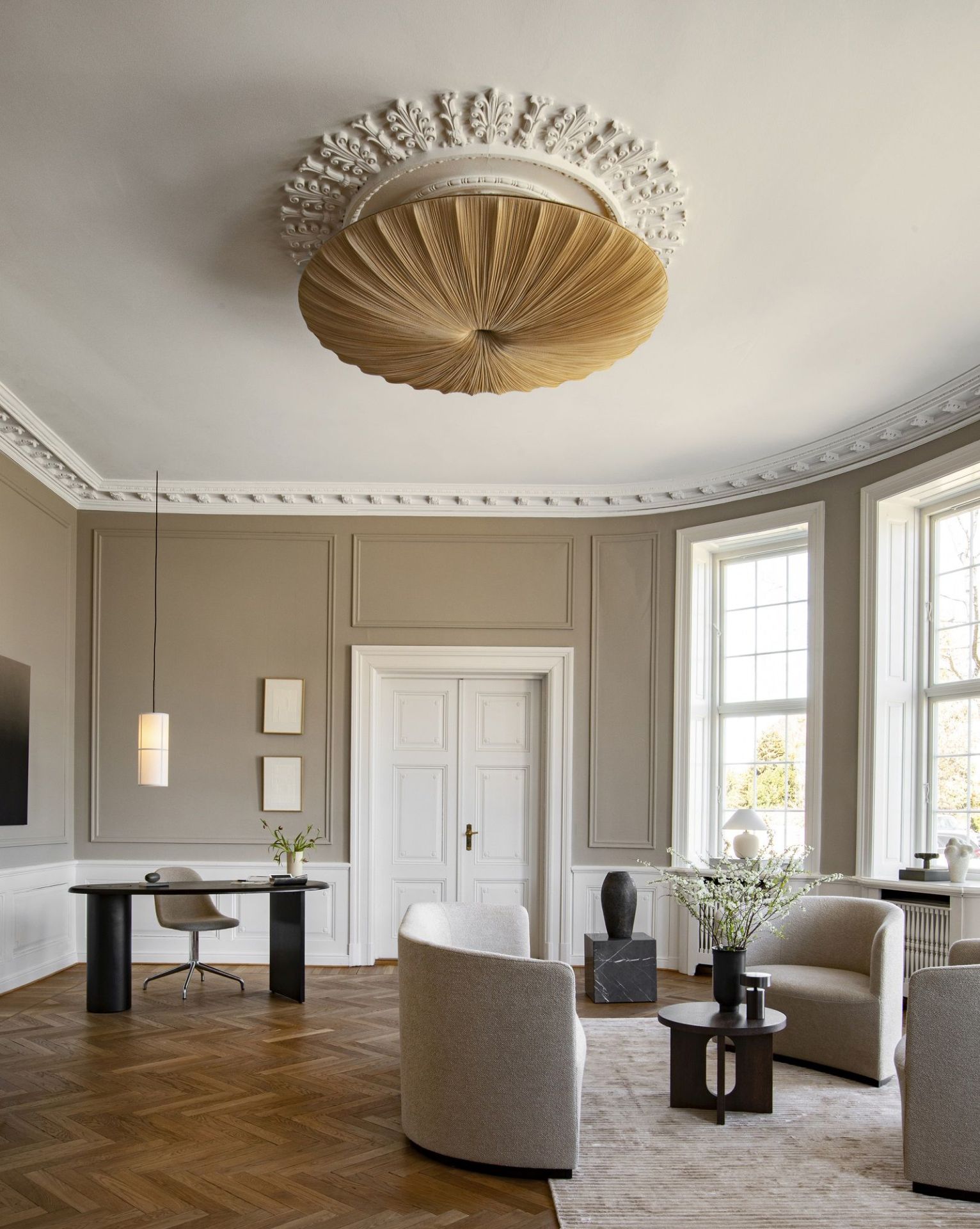 Elegantes Wohnzimmer mit Audo Copenhagen Eclipse Desk Schreibtisch, Designermöbeln und natürlichem Licht für stilvolles Arbeiten.