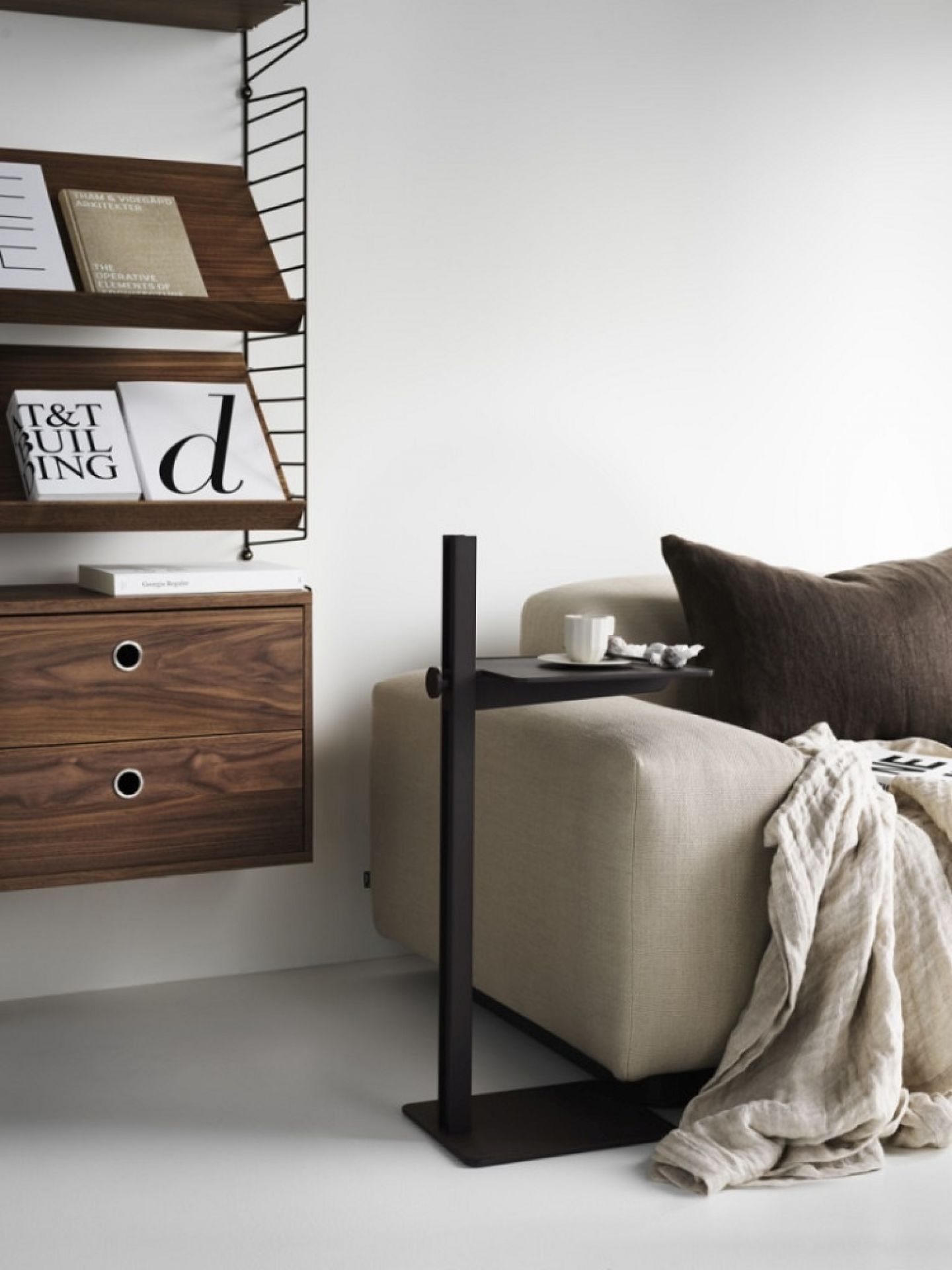 Museum Sidetable Beistelltisch von String Furniture in Schwarz neben einem Sofa, höhenverstellbar für Wohnzimmer.