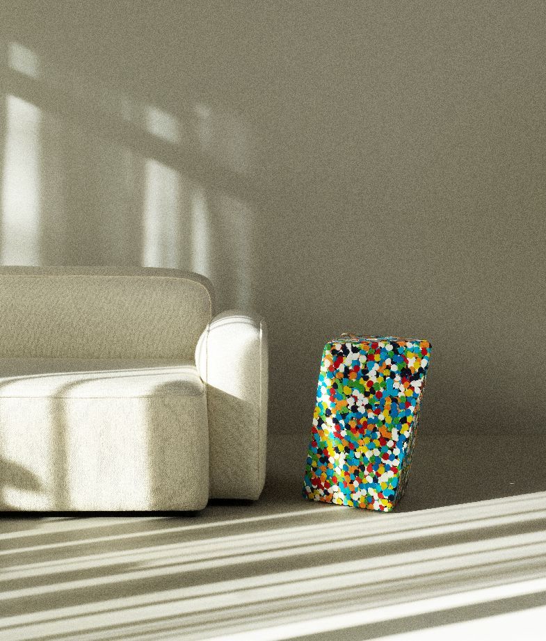 Delta Proust Beistelltisch von Normann Copenhagen, bunter Akzenttisch neben einem beigen Sofa im sonnigen Wohnzimmer.