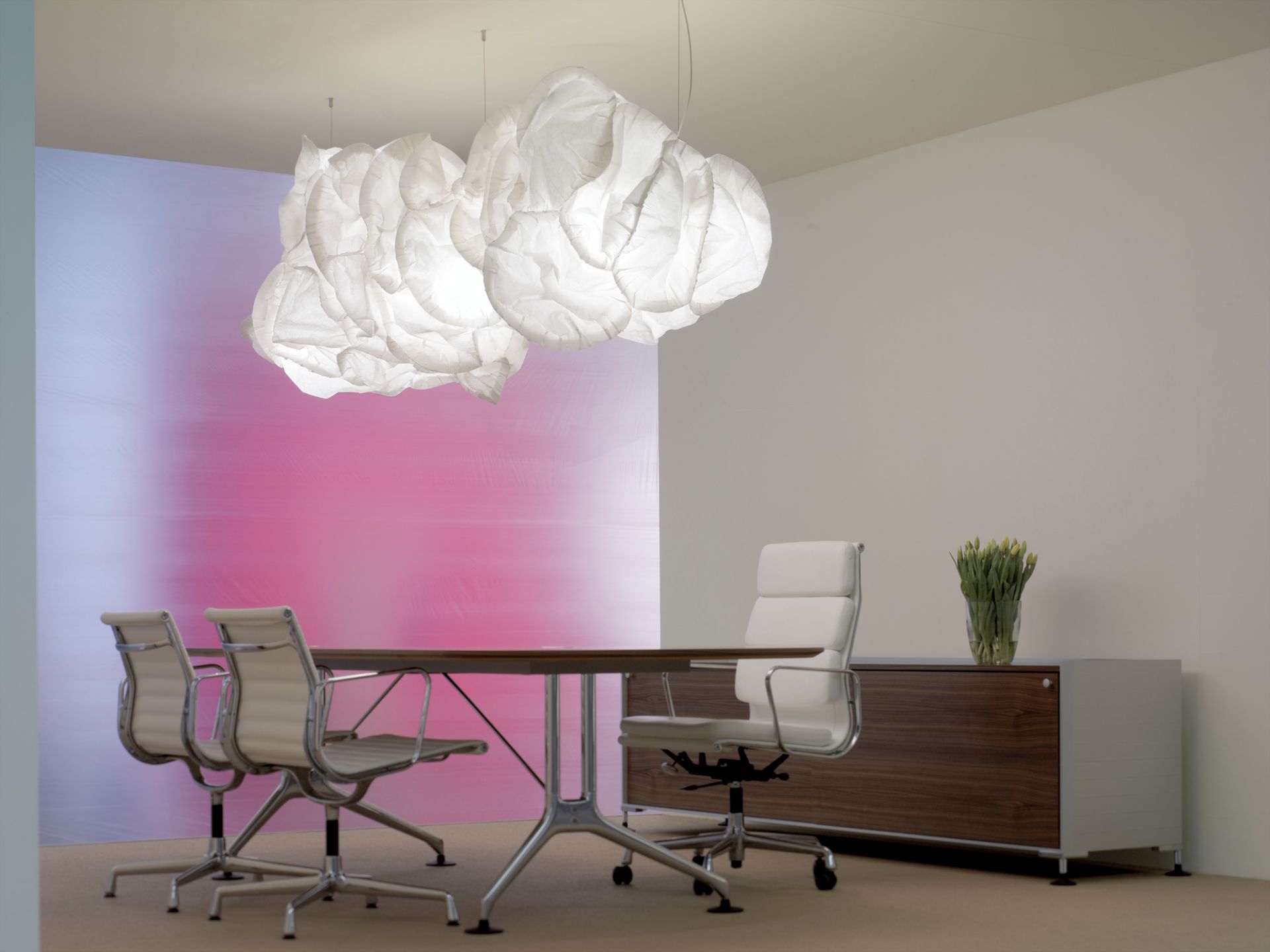 Nahaufnahme der Belux Mamacloud Pendelleuchte, die über einem Konferenztisch in einem modernen Büro hängt.