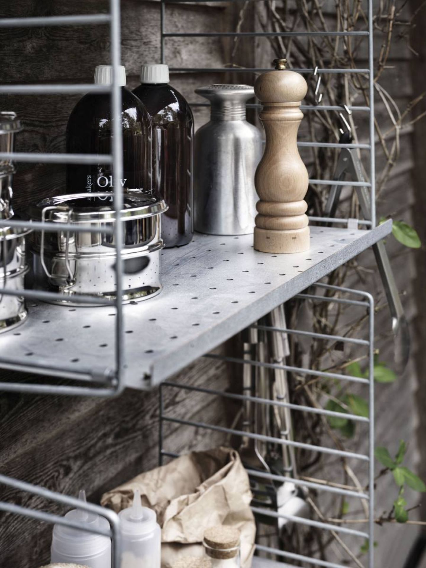 Detailaufnahme eines String Outdoor Regalsystems mit Küchenutensilien und Lebensmitteln.