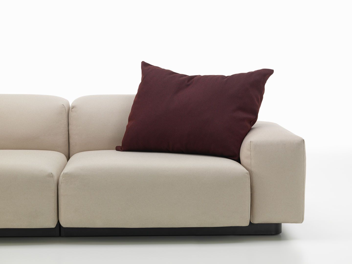 Vitra Kissen in Bordeaux auf einem beigen Sofa, modernes Wohnzimmer-Accessoire für mehr Komfort.