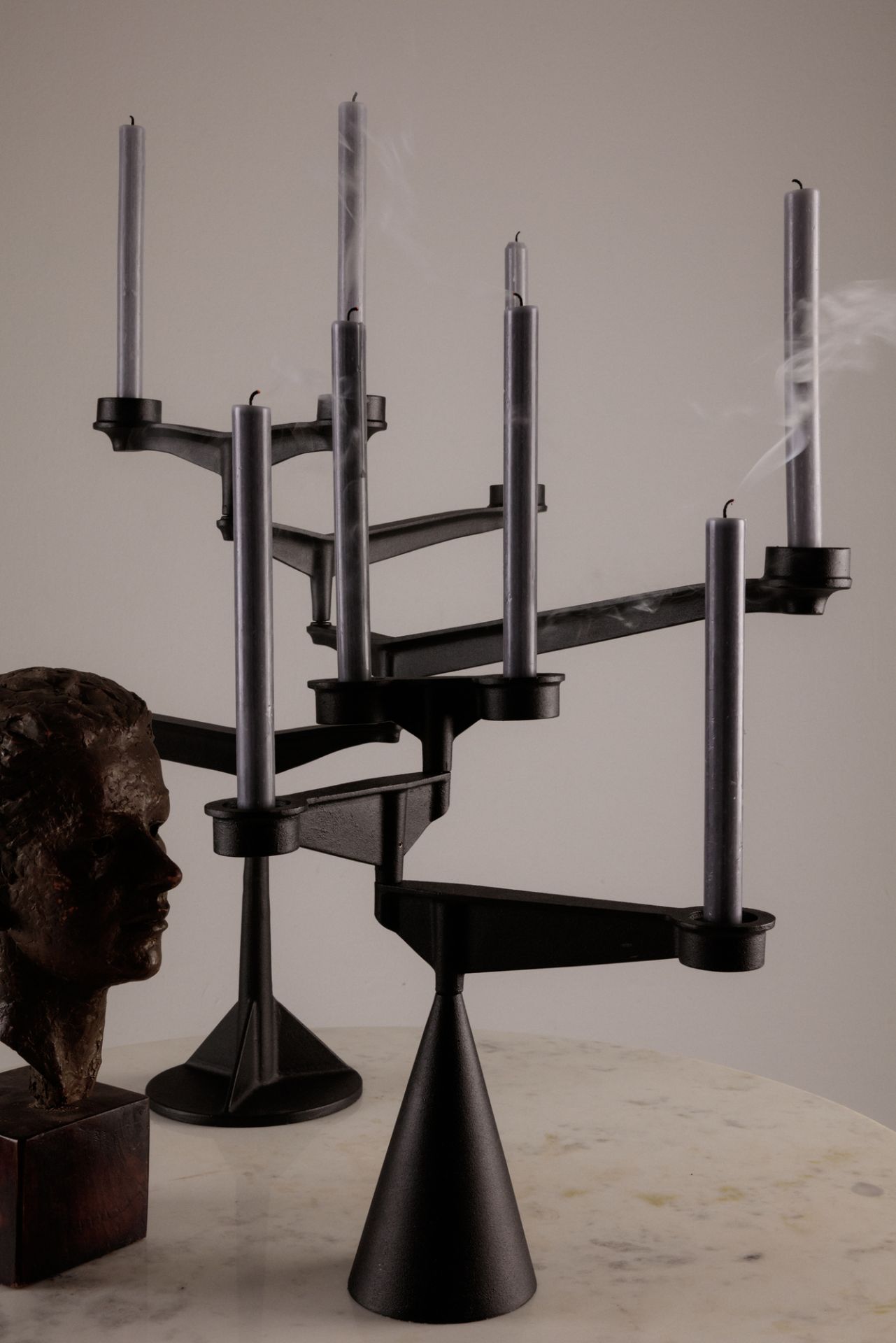 Spin Candelabra Mini Kerzenständer von Tom Dixon mit grauen Kerzen und Skulptur auf Marmortisch.