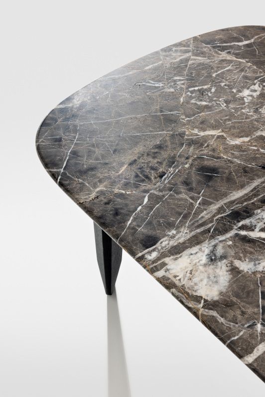 Detailaufnahme der Marmorplatte des Kuyu Marble Couchtisches mit einzigartiger Maserung und einem dunklen Holzbein.