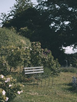 Gardener's Sofa von Design House Stockholm im Garten, eine stilvolle Outdoor Sitzbank zwischen Blumen.
