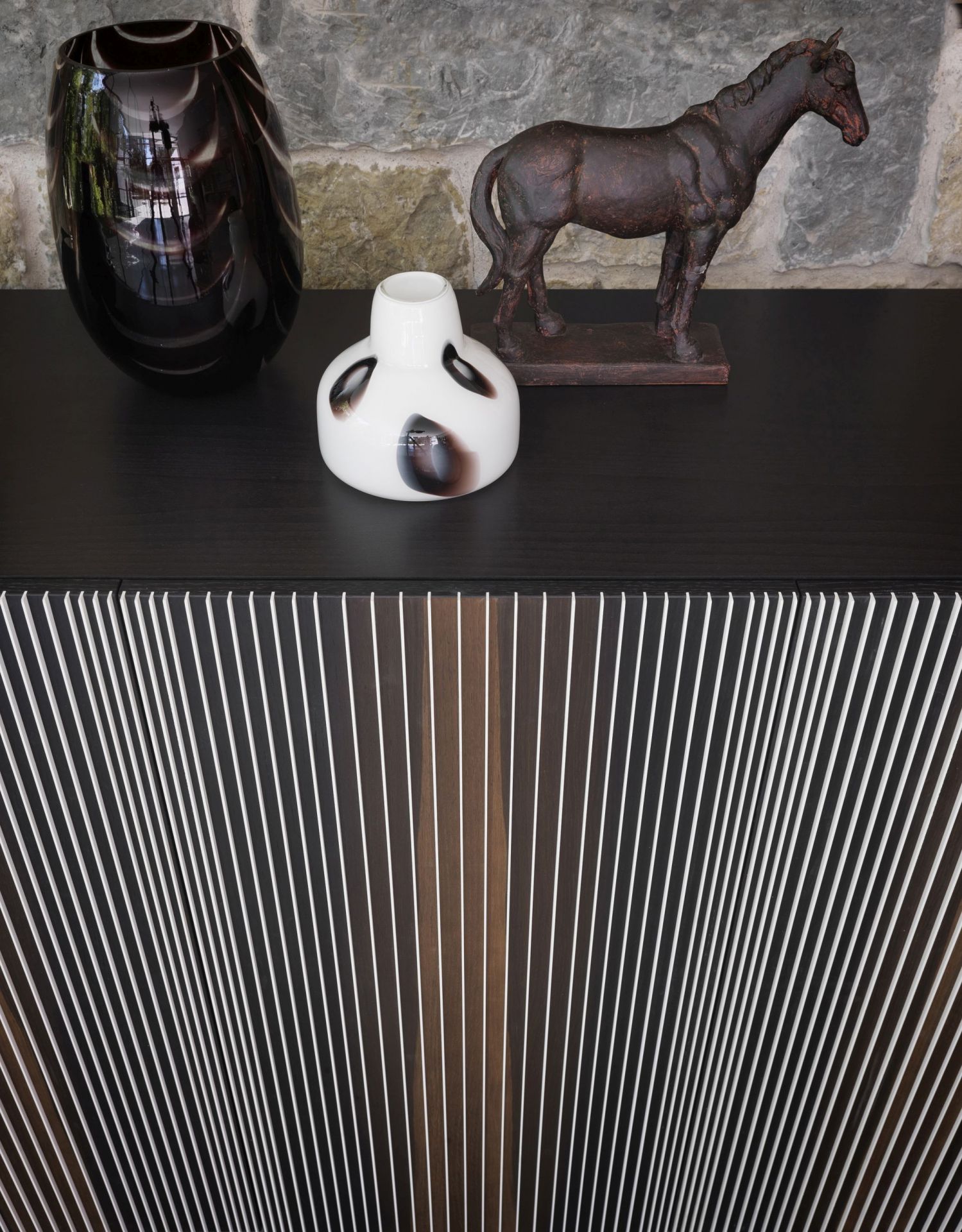 Carlos Anrichte Buche Mokka: Detailansicht des modernen Sideboards mit vertikalen, weißen Linien und Dekoration.