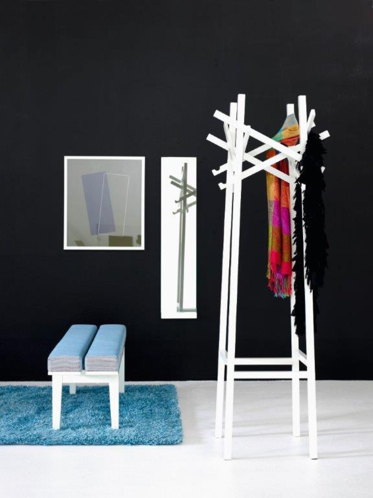 Weiße Nest Standgarderobe von Karl Andersson & Soener mit Schal und Federboa vor schwarzer Wand.