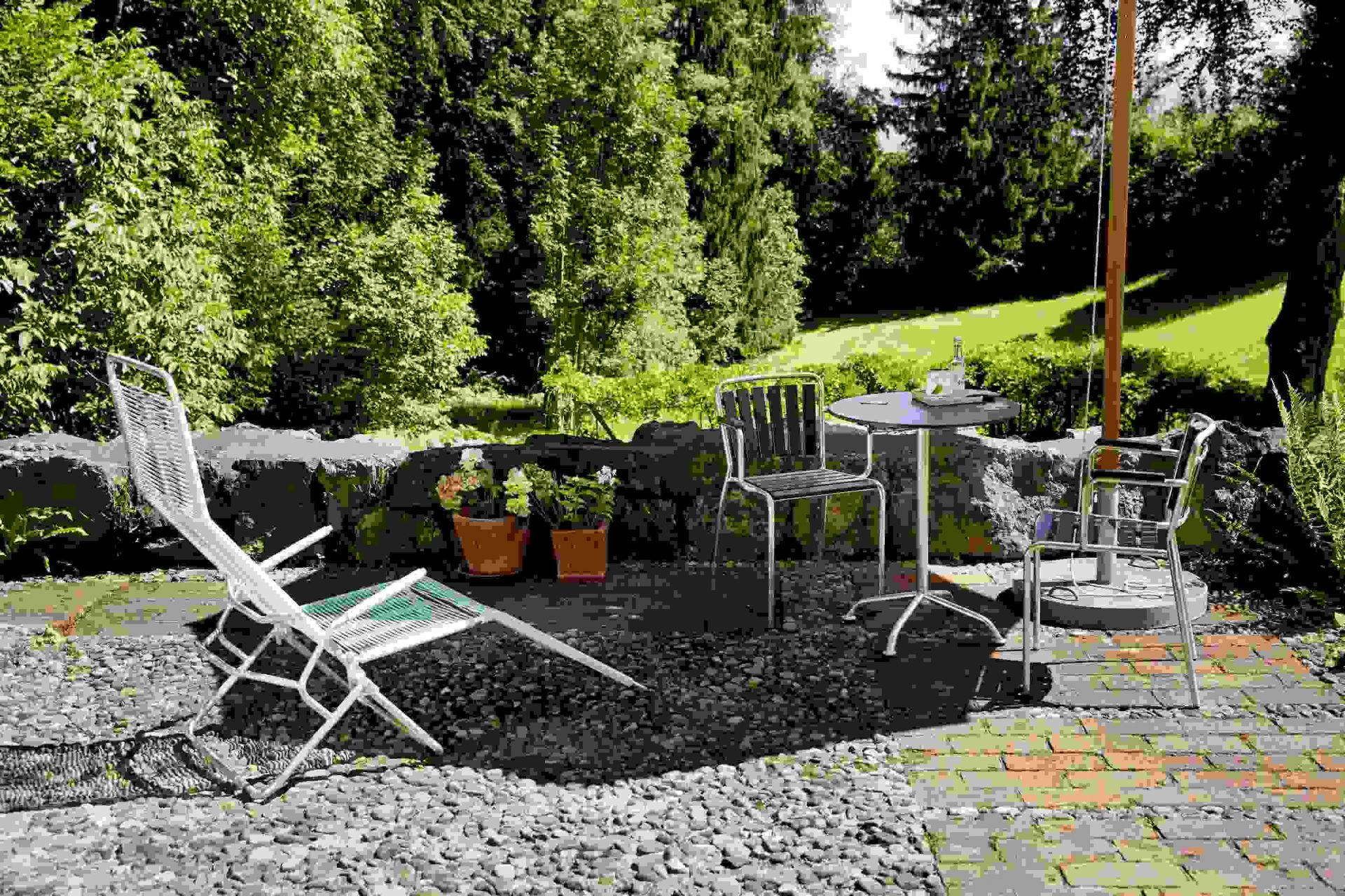 Altorfer Liegestuhl im Garten: Outdoor-Liege mit Tisch und Stühlen auf Terrasse.