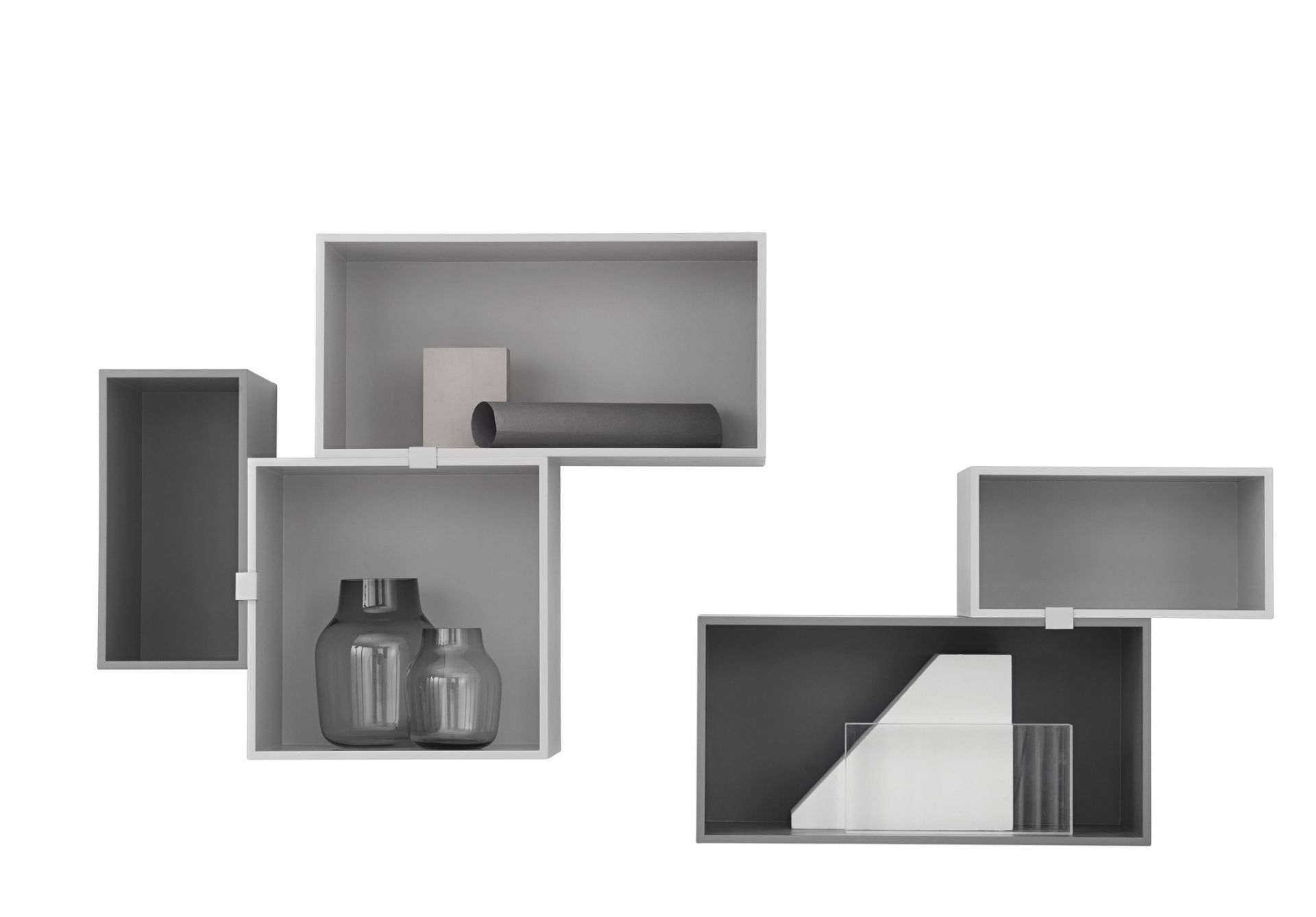 Muuto Mini Stacked Regalsystem 2.0 in Grau und Weiß mit dekorativen Vasen und Objekten.