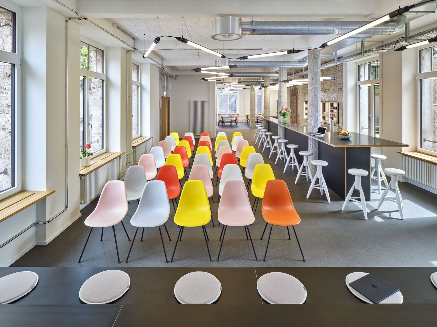 Eames Fiberglass Chair DSX Stühle von Vitra in verschiedenen Farben in einem Konferenzraum.