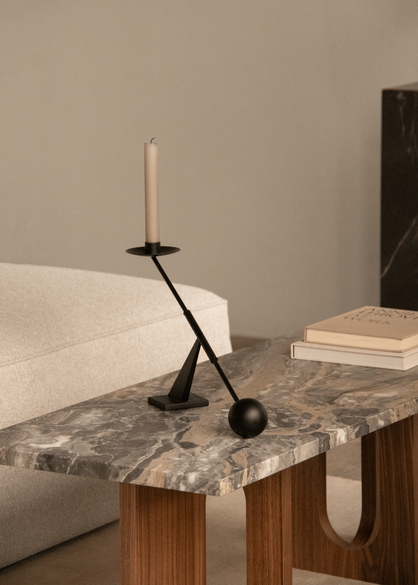 Androgyne Couchtisch von Audo Copenhagen mit Marmorplatte, Kerzenständer und Büchern im modernen Wohnzimmer.