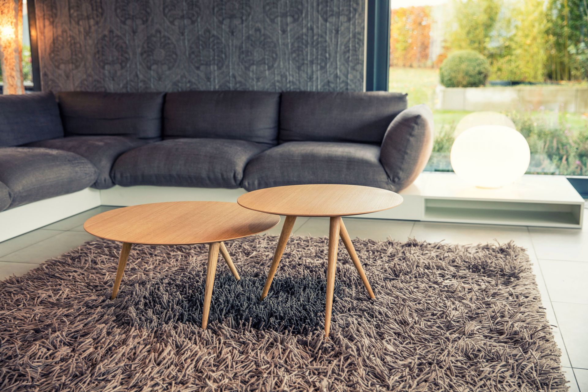 Turn high Beistelltisch Esche weiß Maigrau, zwei runde Holztische auf einem zotteligen Teppich im Wohnzimmer.