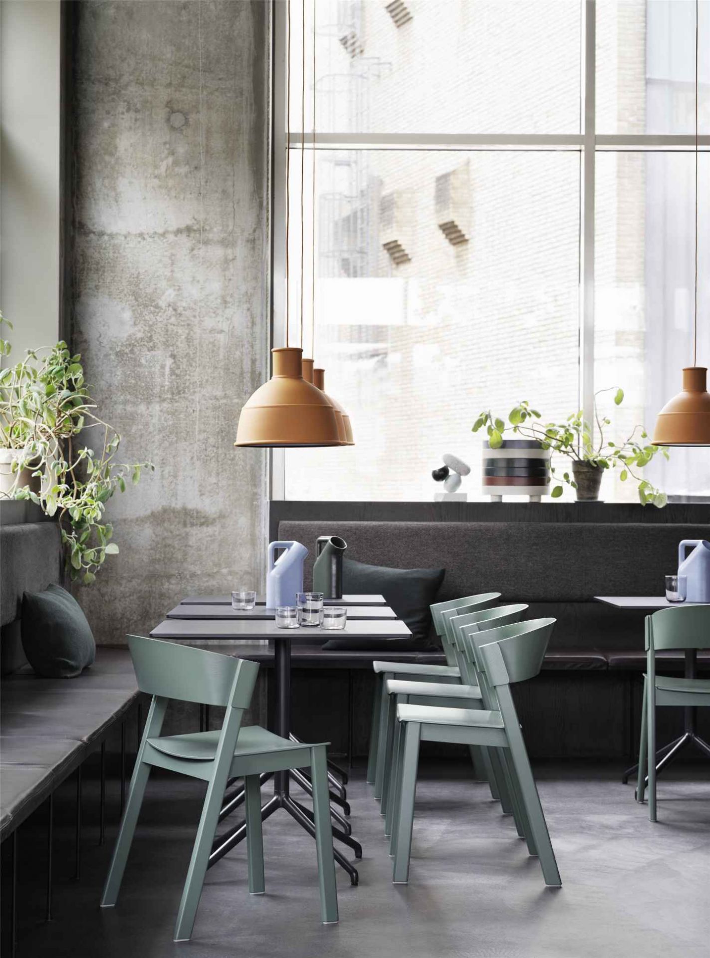 Innenaufnahme: Muuto Cover Side Chair Stuhl in Grün an Esstisch mit Pendelleuchten.