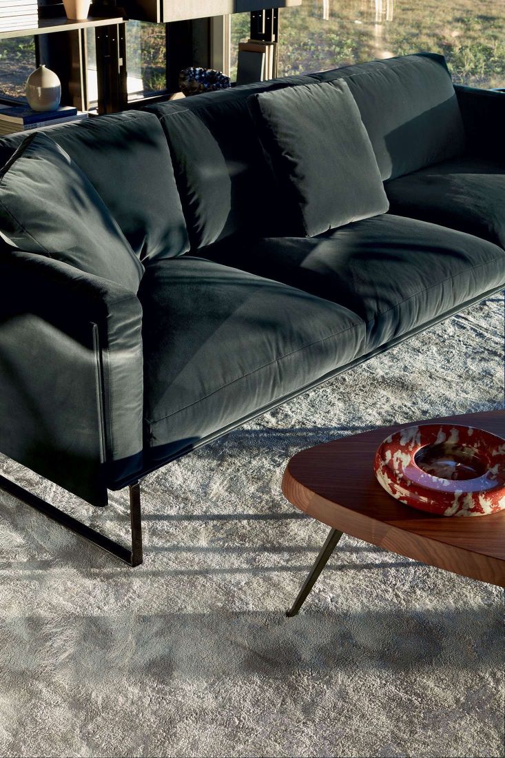 Nahaufnahme des Cassina 527 Mexique Couchtisches aus Holz neben einem modernen Sofa.