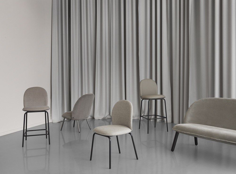 Graue Ace Chair Stühle von Normann Copenhagen mit Polsterung und schwarzen Metallbeinen vor grauem Vorhang.