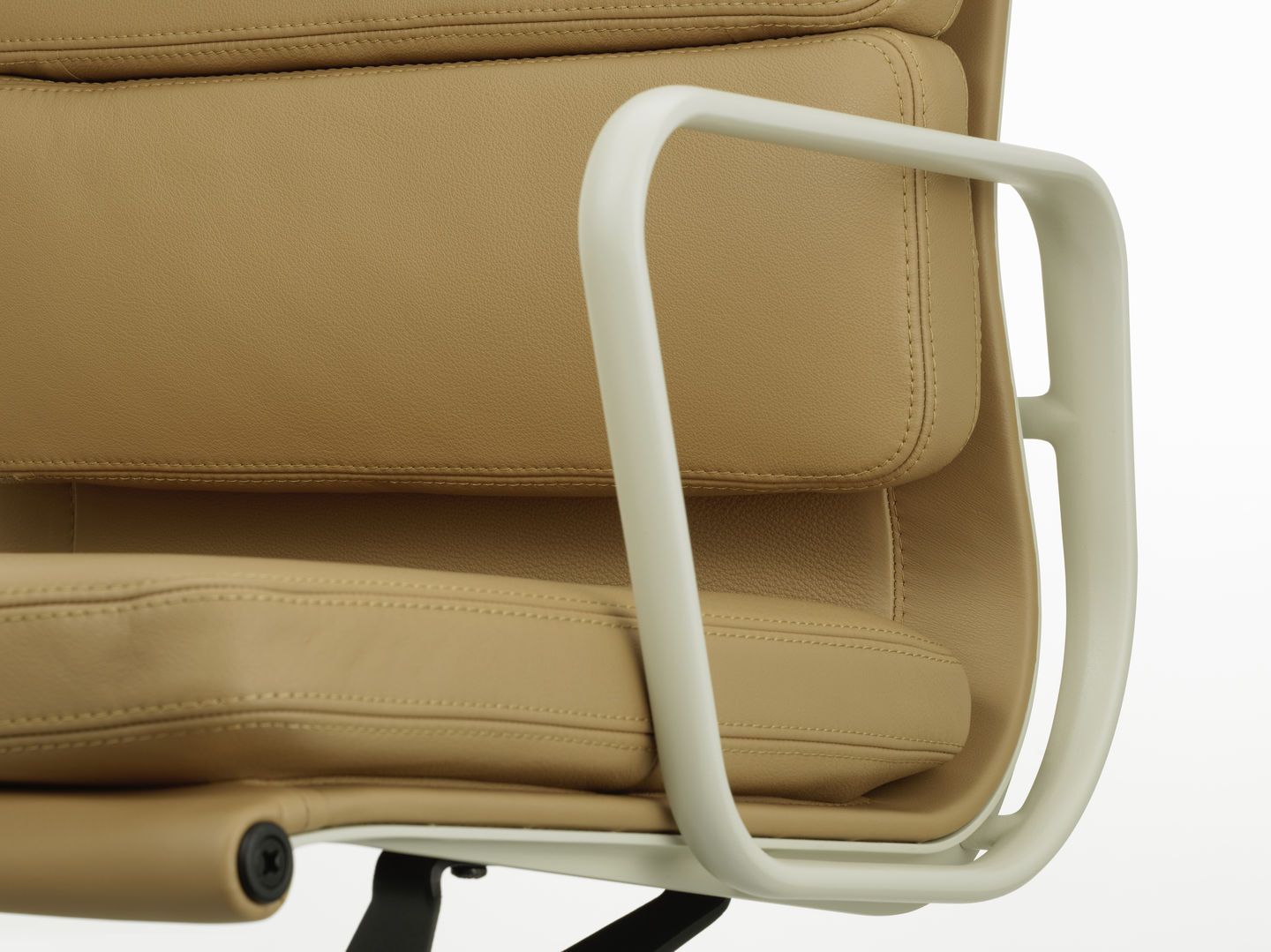 Detailaufnahme des Soft Pad Chair EA 231 von Vitra mit beigem Leder und weißen Armlehnen.